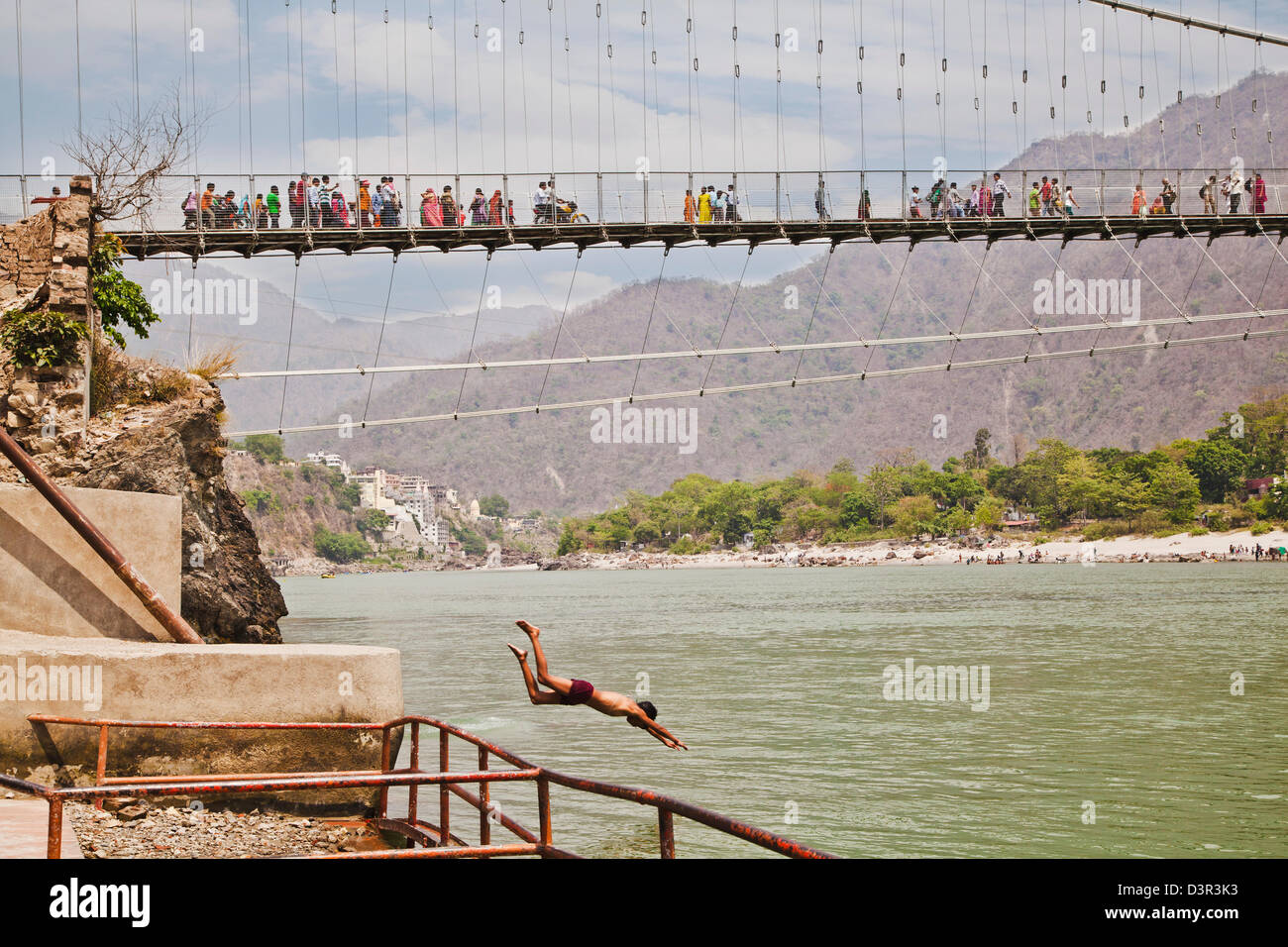 People on Ram Jhula across the Ganges River, Rishikesh, Uttarakhand, India Stock Photo