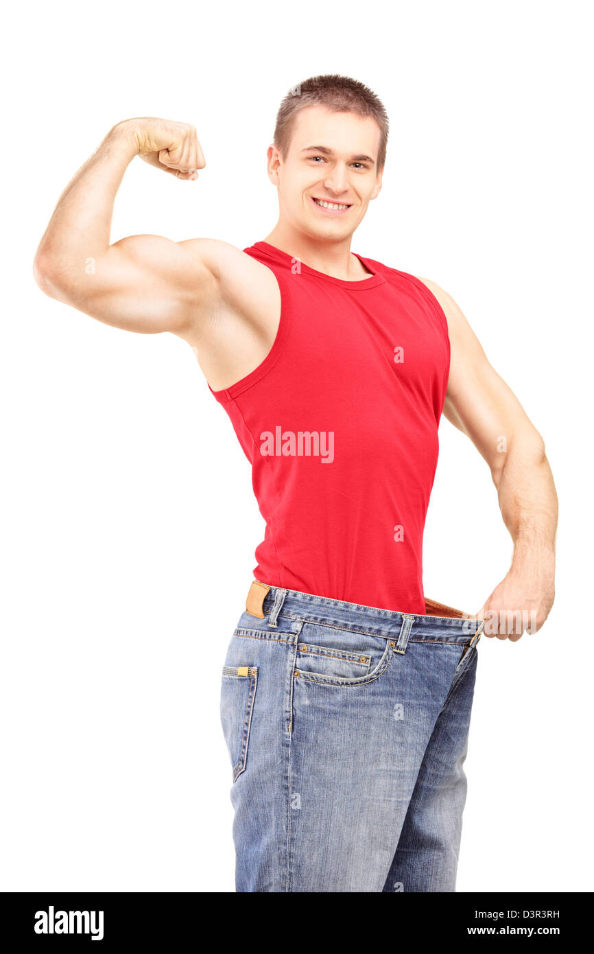 Weight loss man in an old pair of jeans showing his muscular body isolated on white background Stock Photo