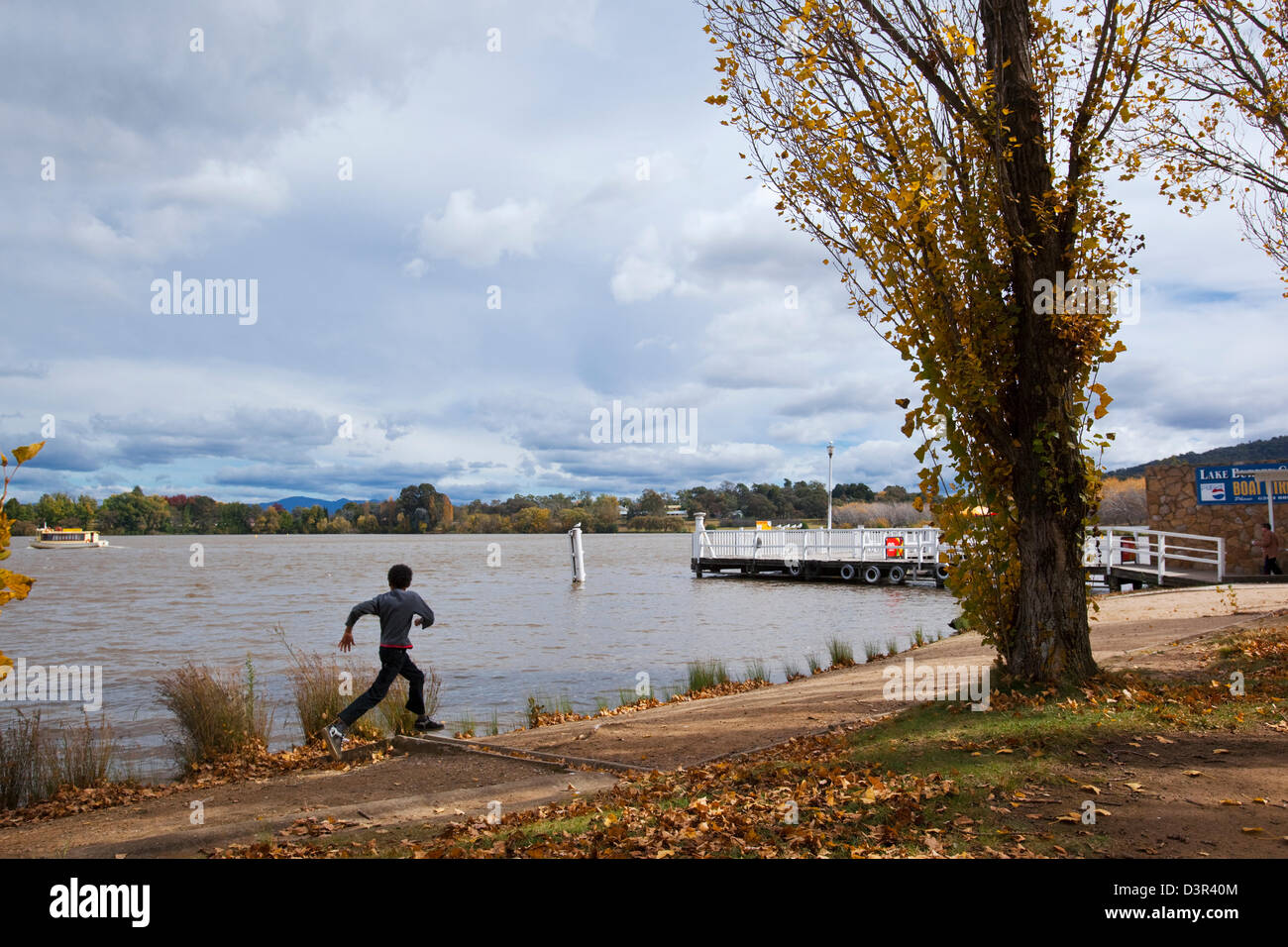 Child running along waterfront of Lake Burley Griffin. Canberra, Australian Capital Territory (ACT), Australia Stock Photo