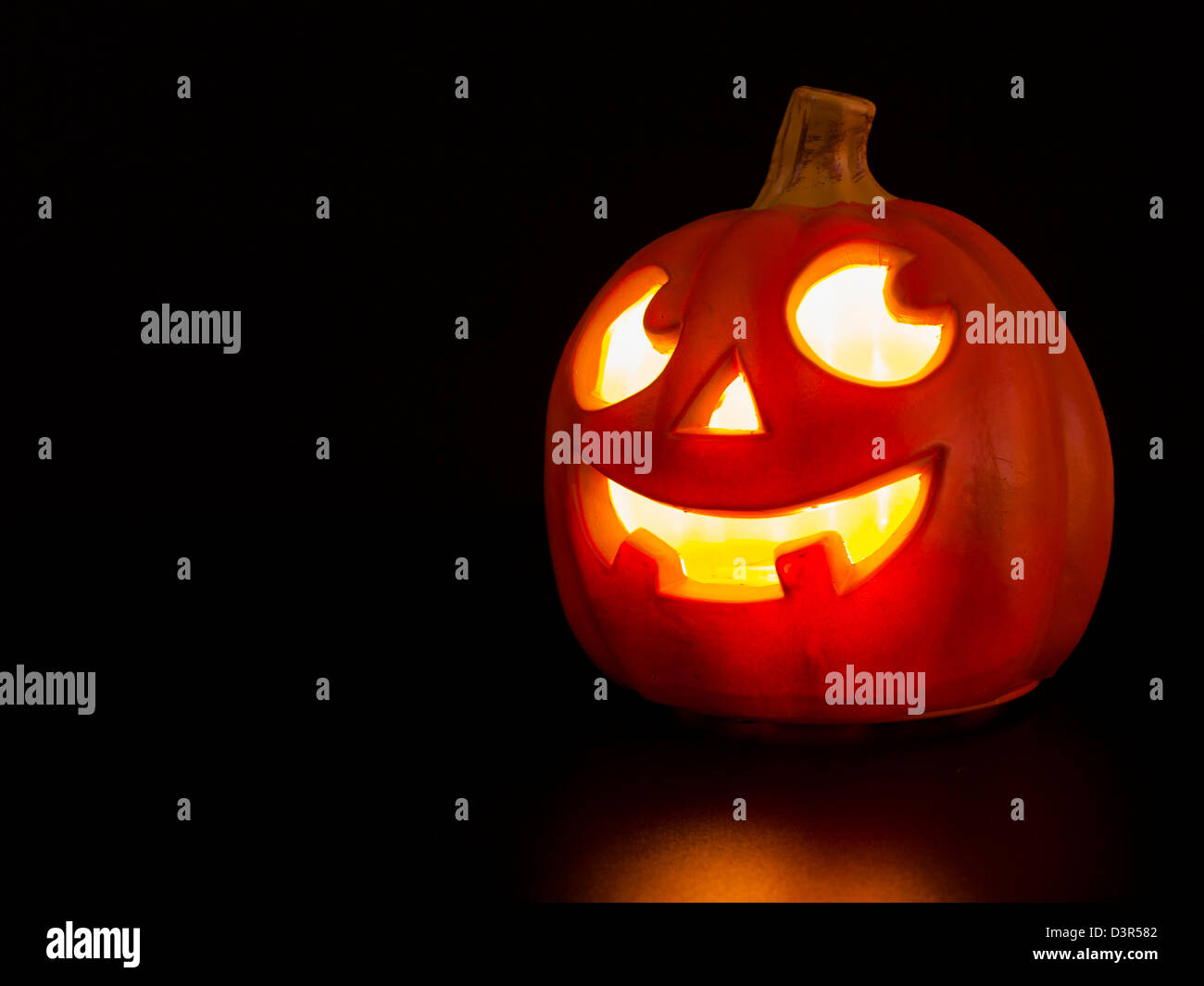 Lit jacko'lantern on black background Stock