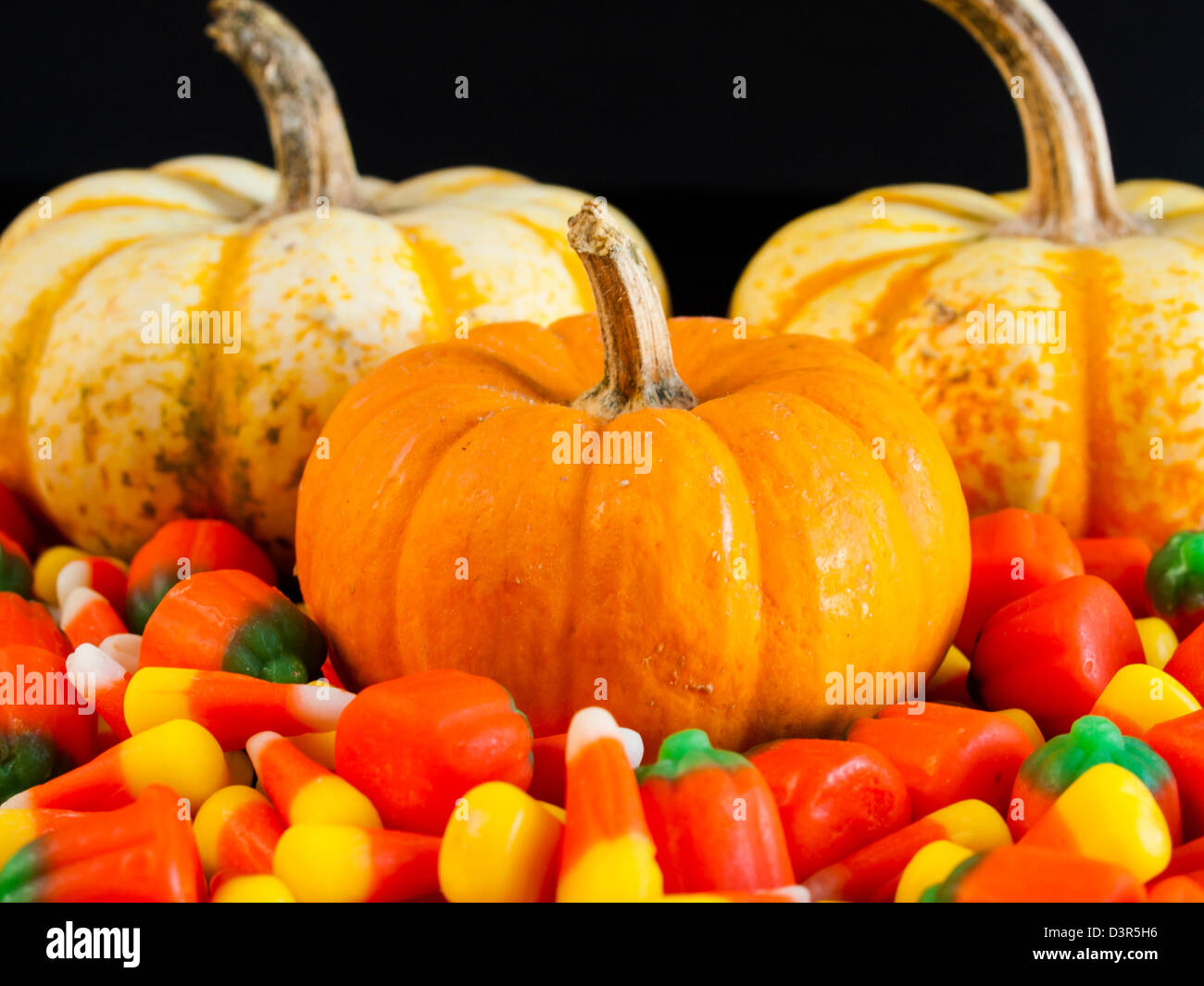 Halloween candy corn and pumpkin candies on black background Stock