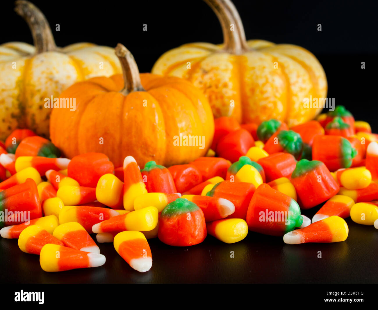Halloween candy corn and pumpkin candies on black background Stock