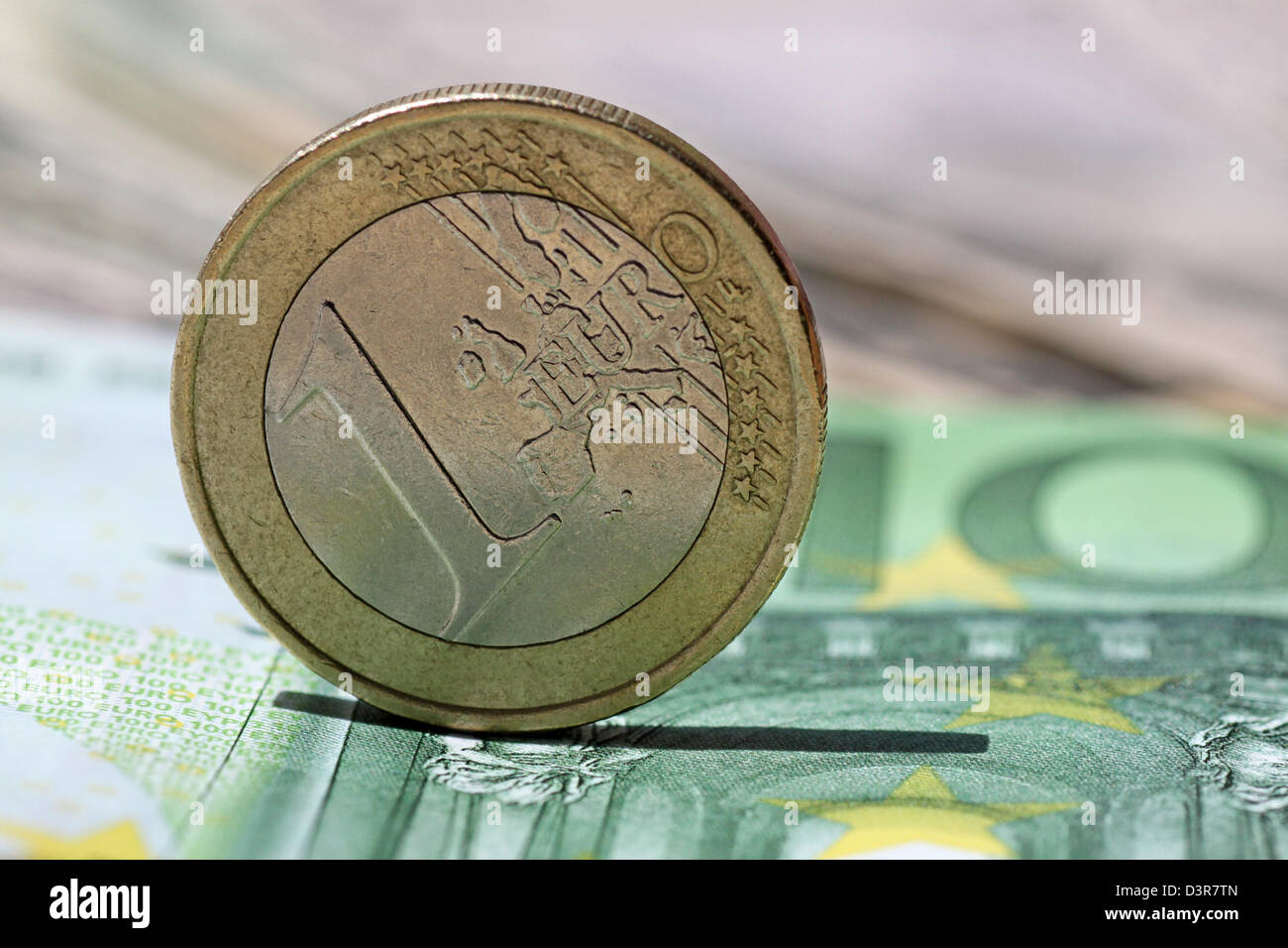 one euro coin on one hundred euro banknote Stock Photo