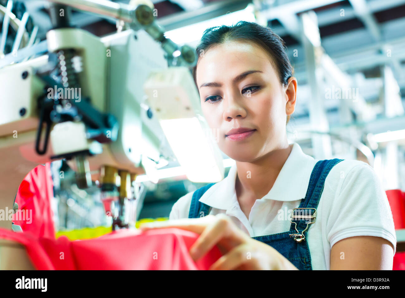 Seamstress or worker in a factory sewing with a industrial sewing machine, she is very accurate Stock Photo