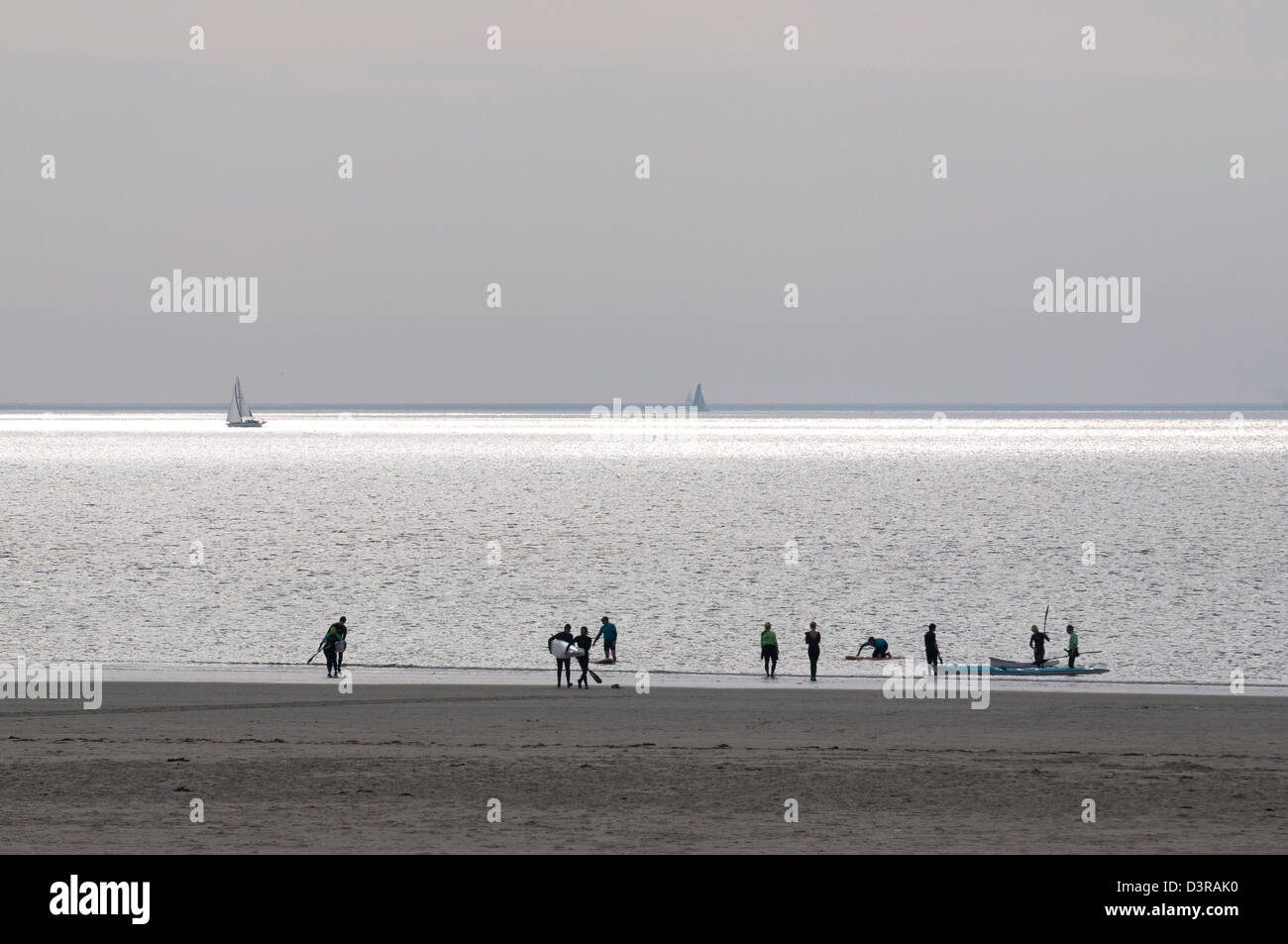 Surfers at the end of the day, St Ouen's, Channel Islands Stock Photo