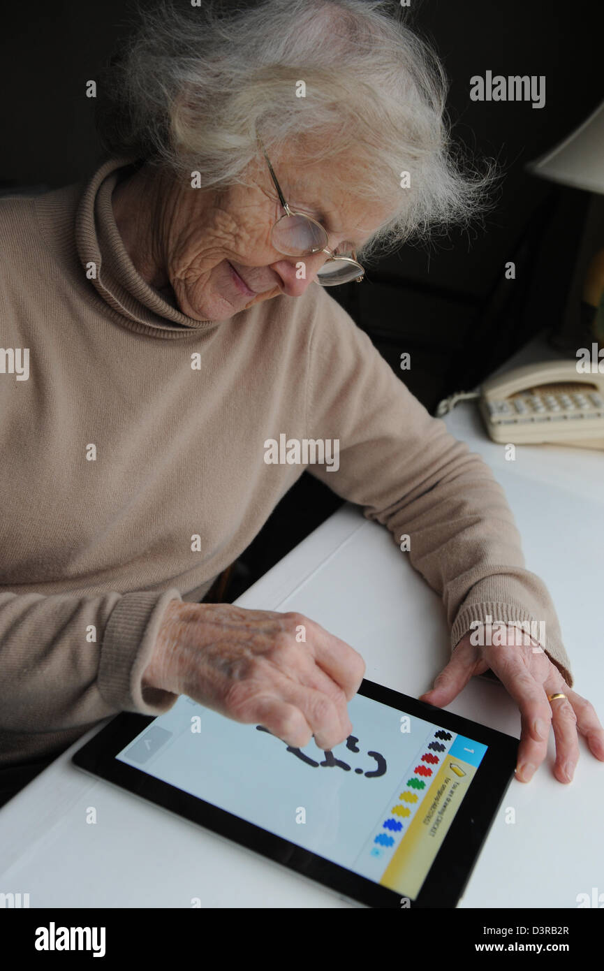 Elderly lady playing a game on an Apple Ipad at home Stock Photo Alamy