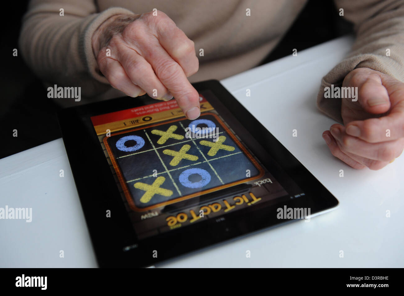Elderly lady playing a game on an Apple Ipad at home Stock Photo Alamy