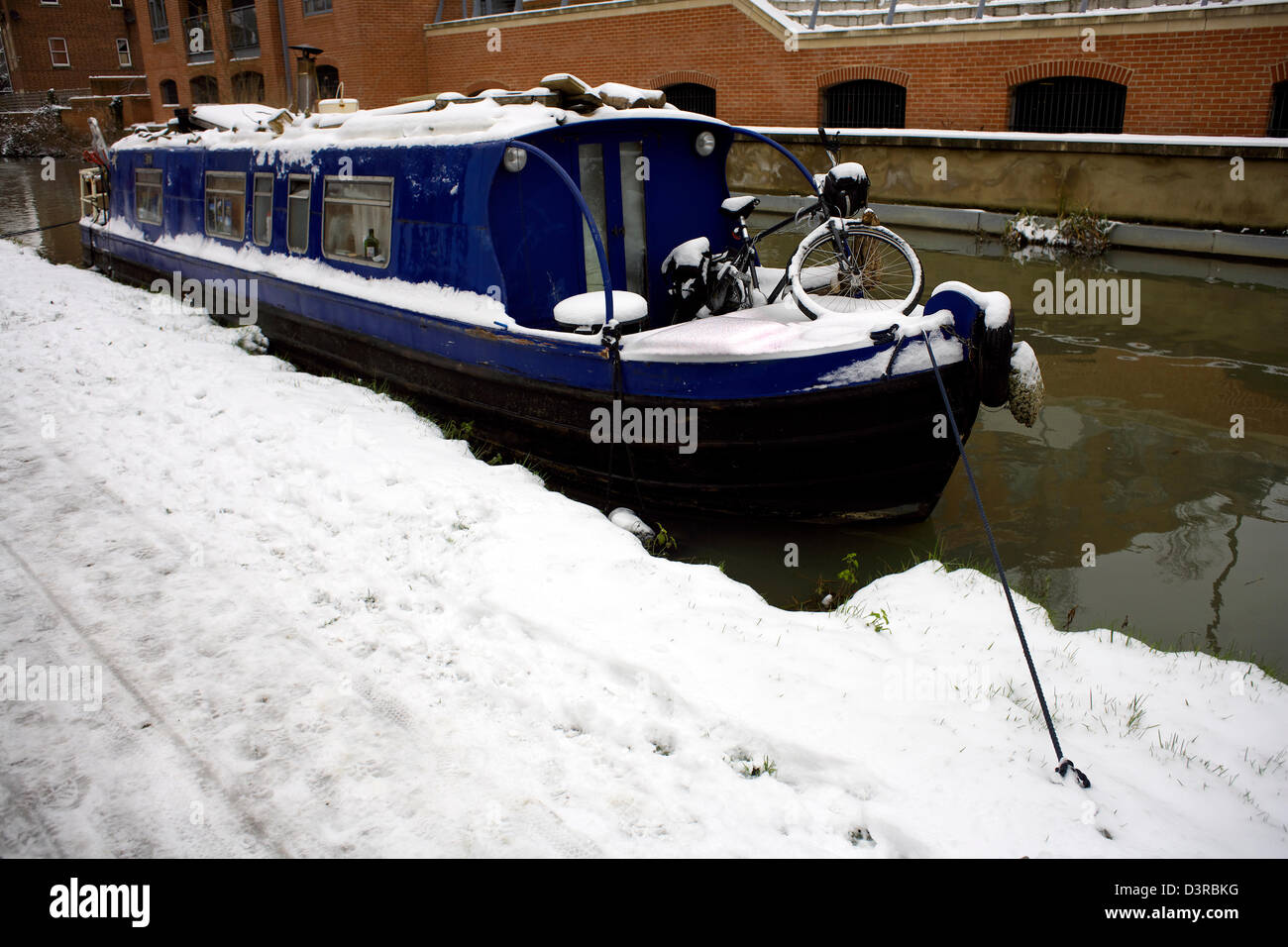 Snow narrowboat and bicycle winter on the South Oxford Canal City of Oxford Oxfordshire Oxon England boat narrowboat narrow Stock Photo