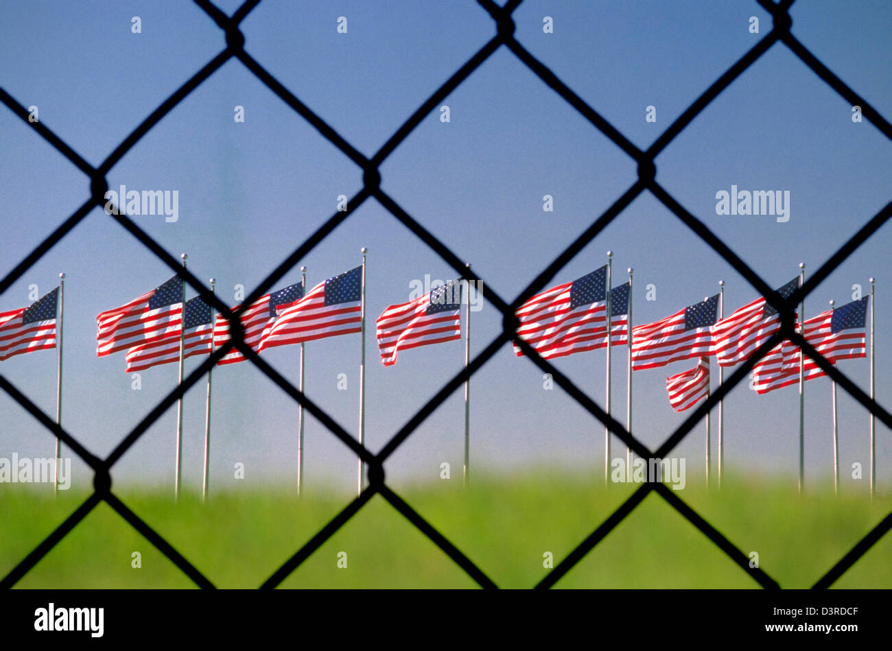chain link fence American flags flying near the Statue of Liberty in