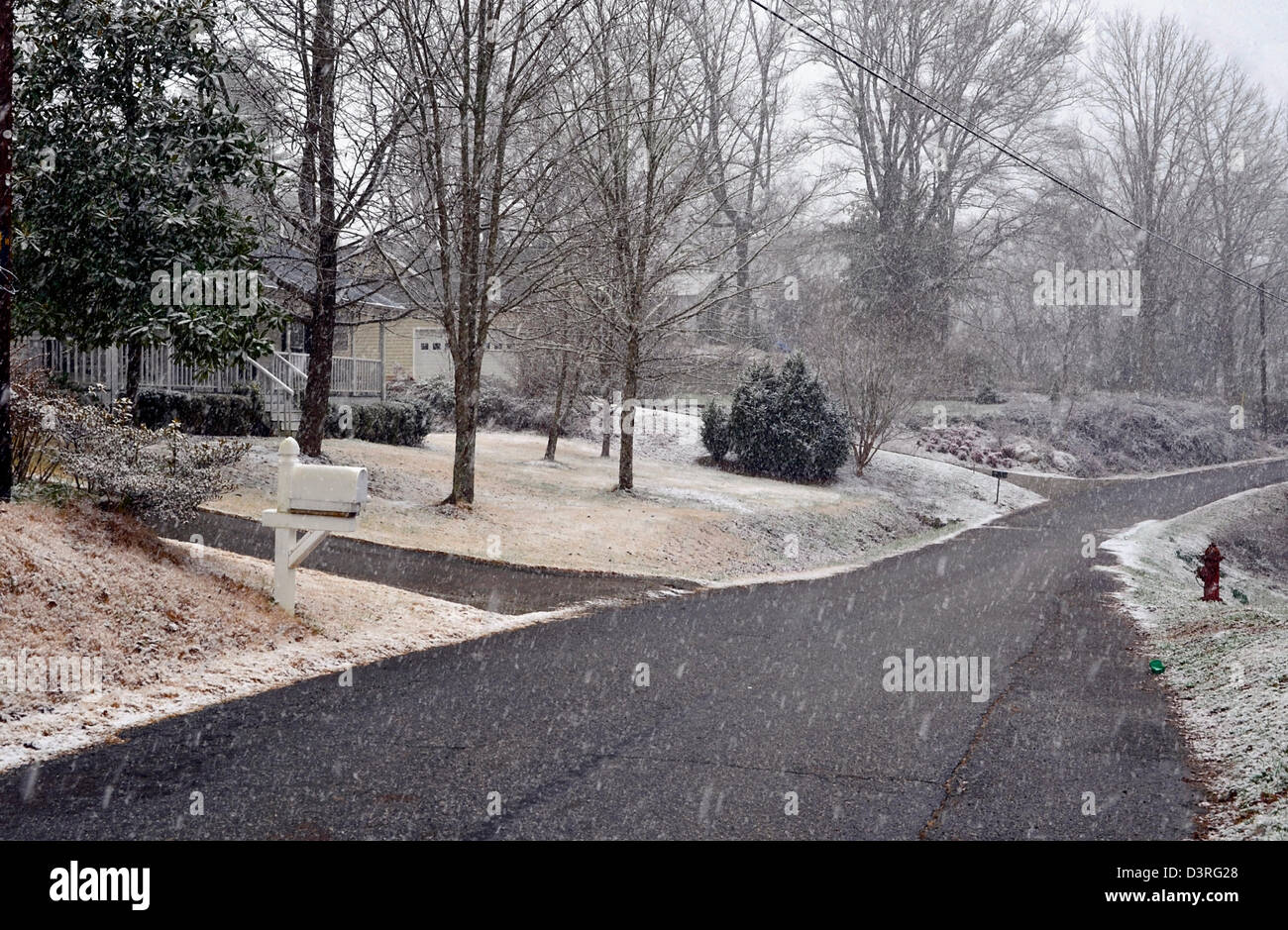 A small neighborhood street with snow beginning to fall. Stock Photo