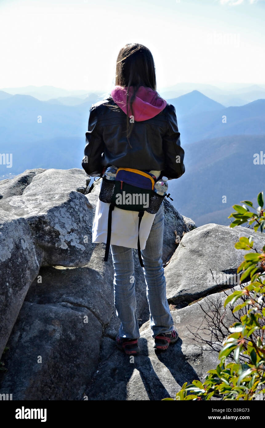 A young girl hiker on a rock outcropping at an overlook enjoying the ...