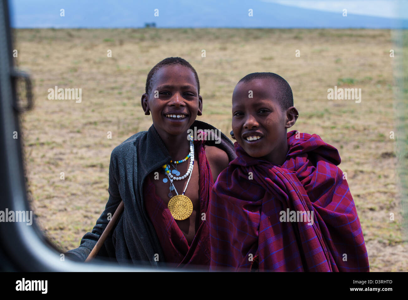 Masai children look into the safari jeep window as captivated by the tourist as they are of them. Tanzania Stock Photo