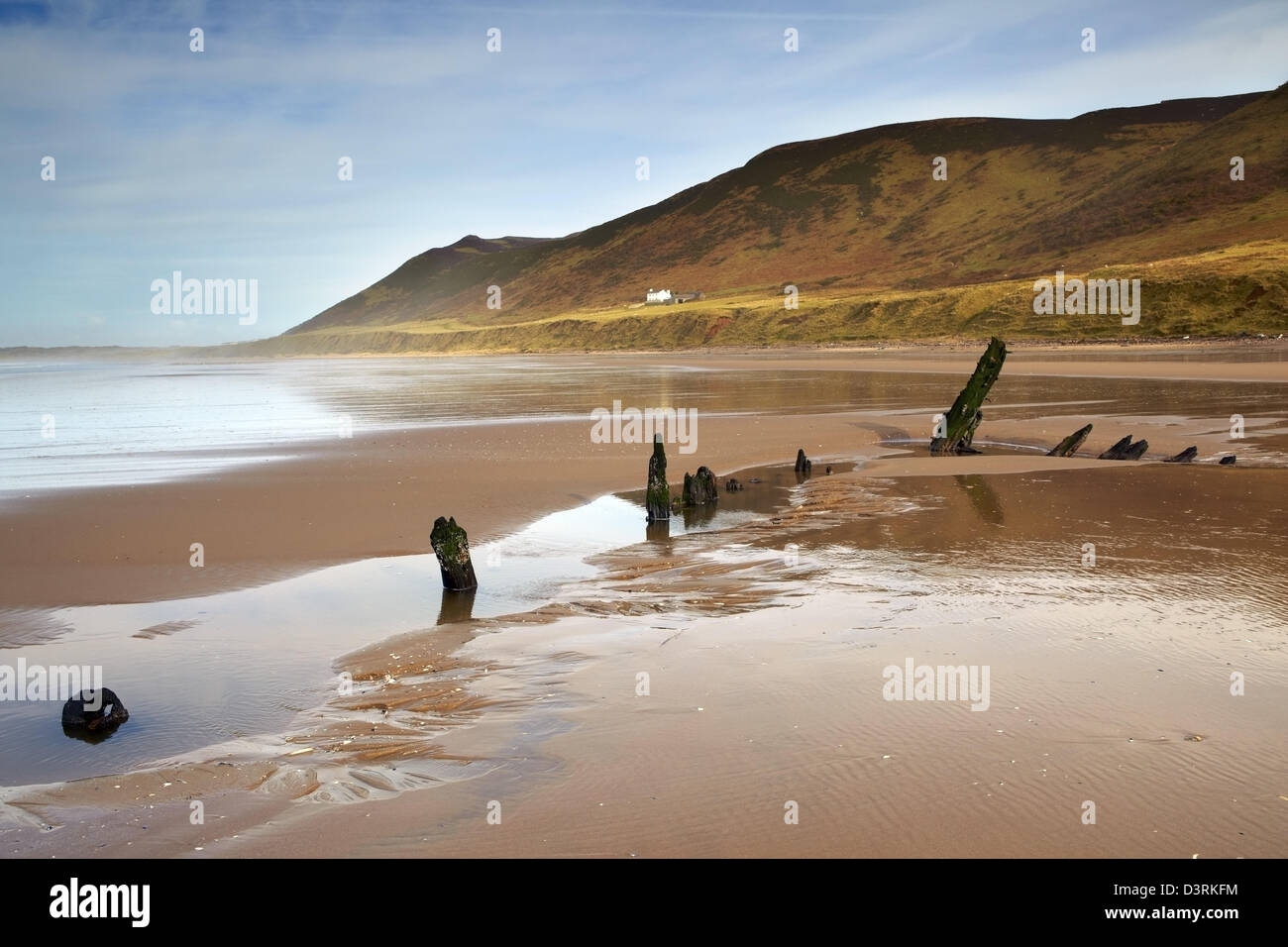 Helvetia wreck on Rhossili Bay, with Rhossili downs and the old Rectory behind, reflected in the wet sand. Winter. Stock Photo