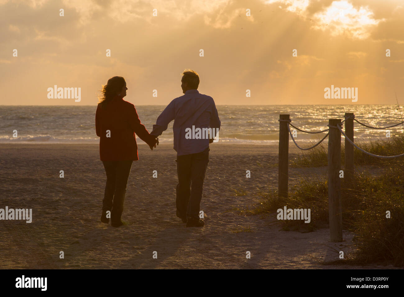 Couple holding hands on Venice Beach in Venice Florida at sunset Stock Photo