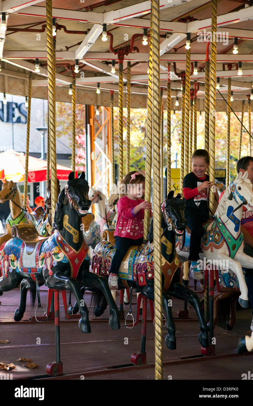 Kids enjoying the Canberra merry-go-round in Petrie Plaza. Canberra, Australian Capital Territory (ACT), Australia Stock Photo
