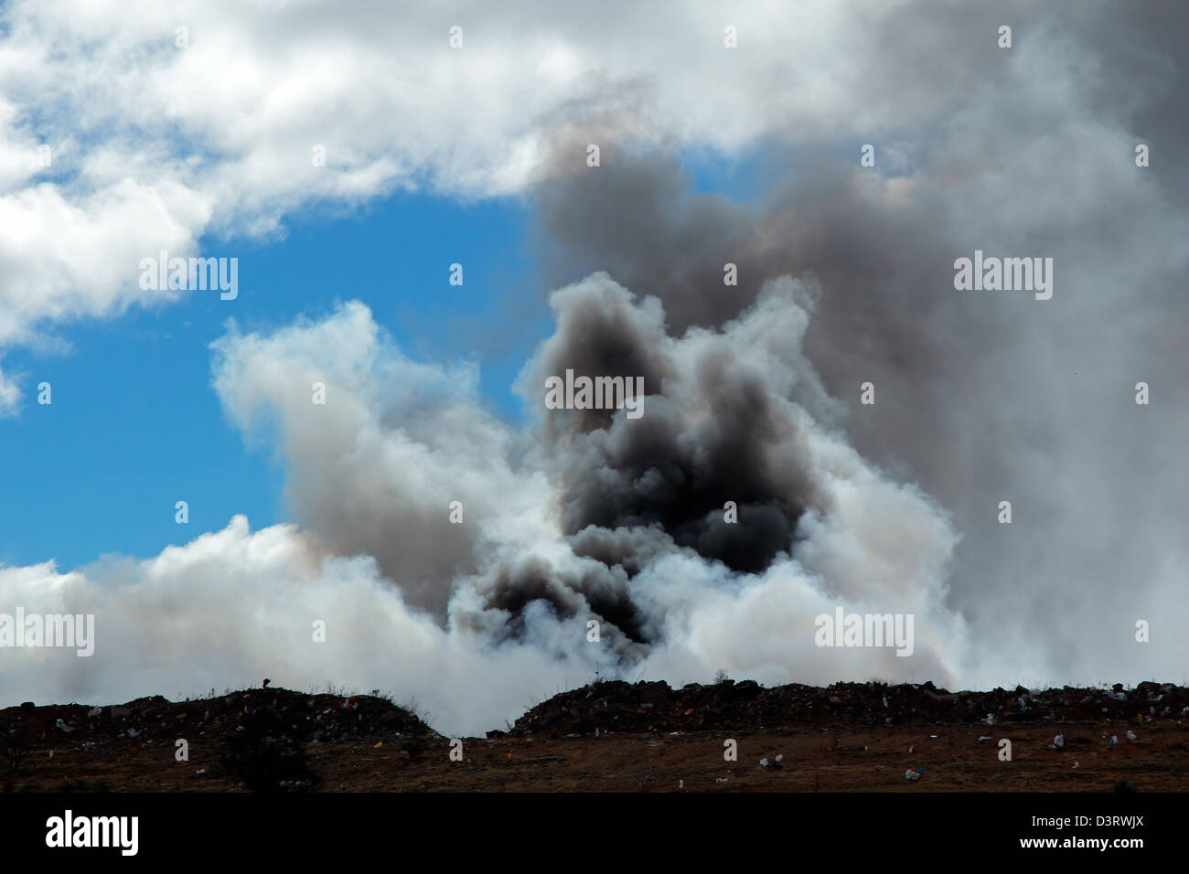 Billowing smoke and pollution from burning waste as a waste disposal site Stock Photo