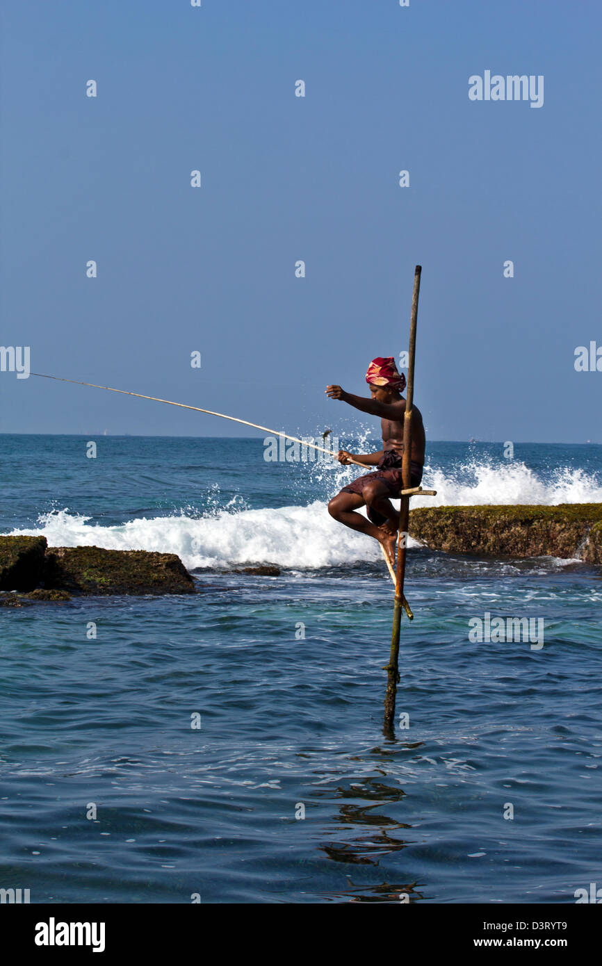 STILT FISHERMAN OF SRI LANKA WITH A FISH Stock Photo - Alamy