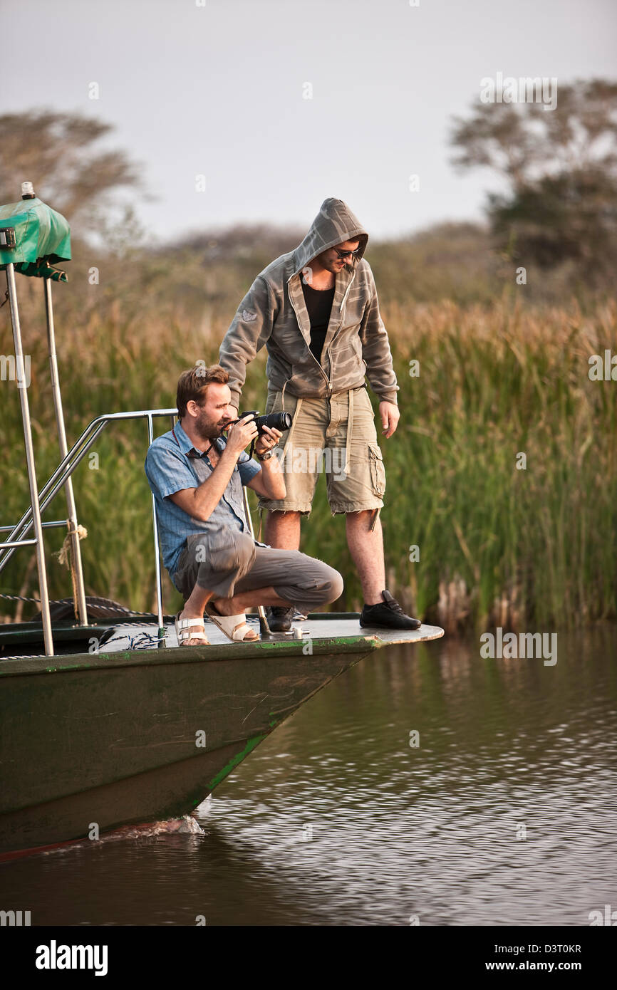 Photographers taking pictures from a boat in Phinda Game Reserve, South Africa Stock Photo