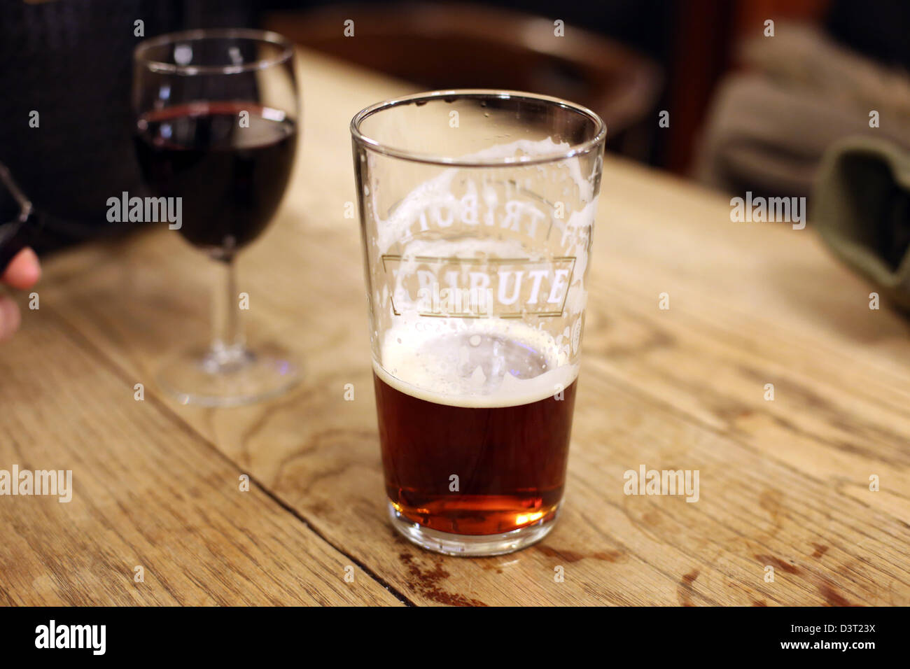 Pint of Bitter glass red wine wooden table pub Stock Photo
