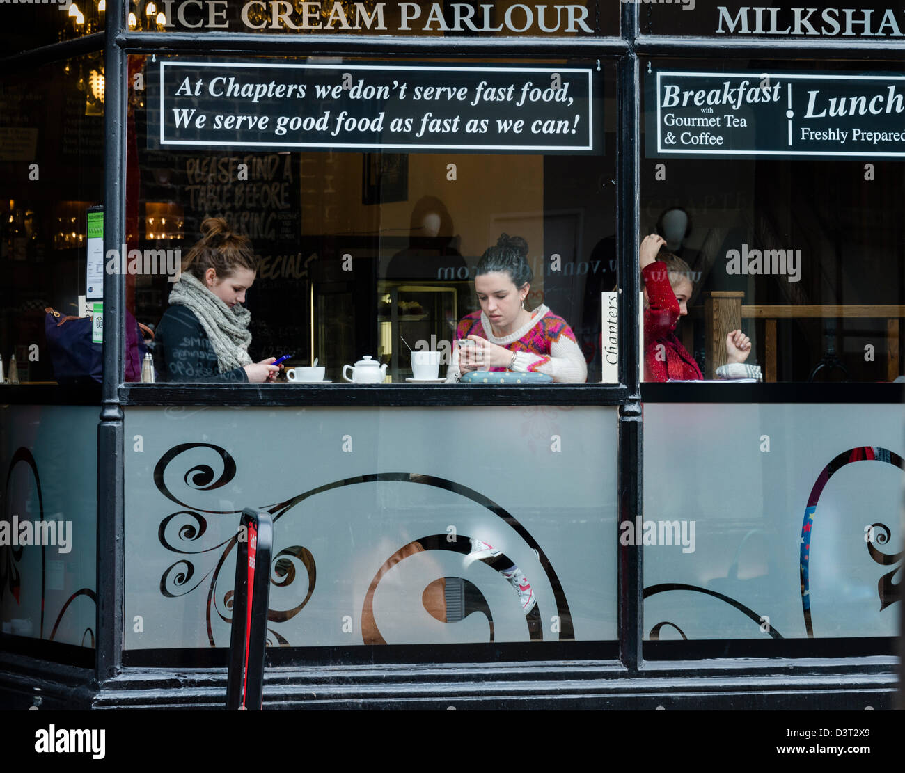 Young women texting in a Durham Tea Shop Stock Photo