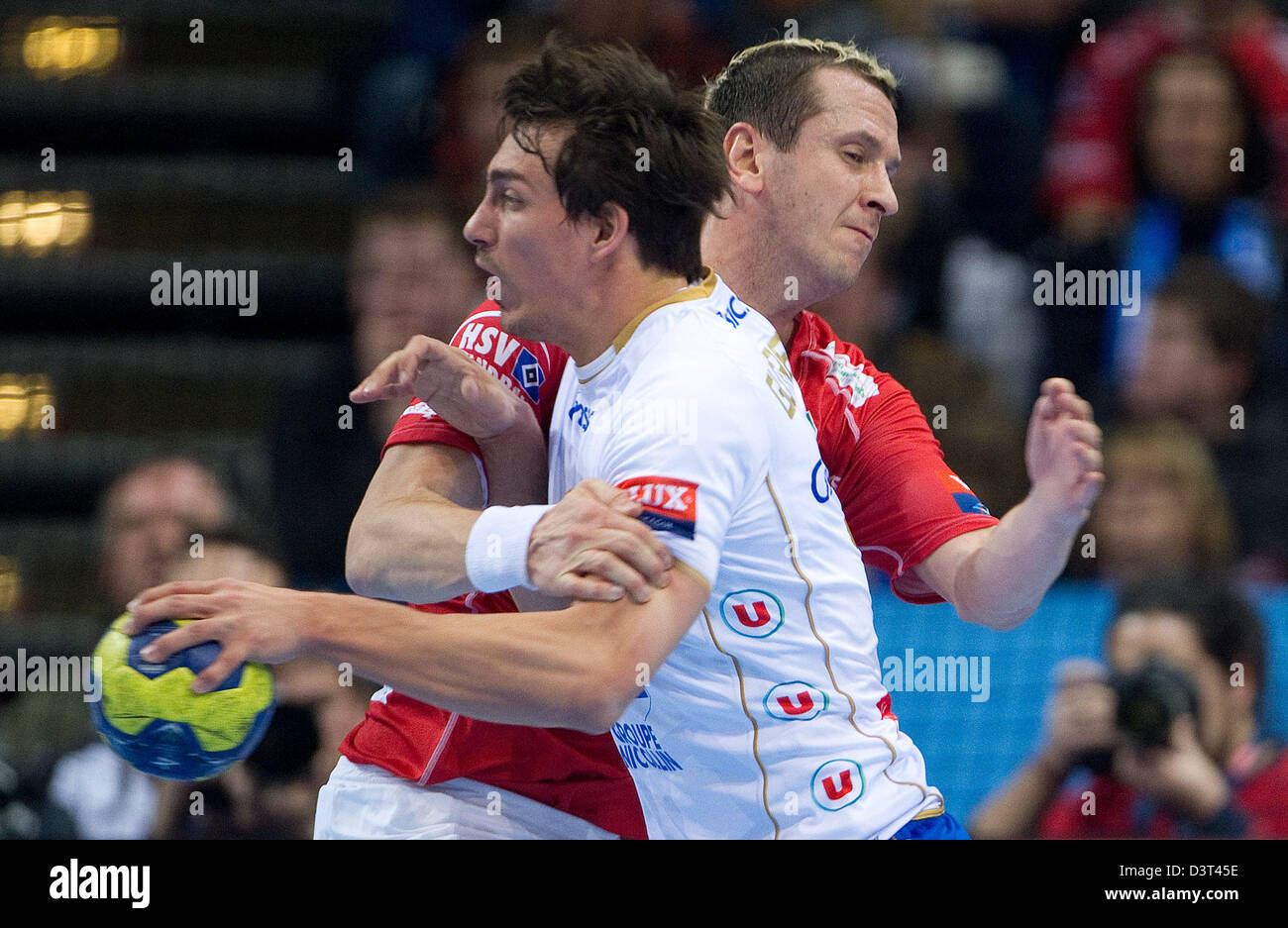 Hamburg, Germany, 23rd Feb, 2013. Montpellier's Antoine Gutfreund (front) and Hamburg's Pascal Hens fight for the ball during the match HSV Hamburg vs Montpellier AHB at the Handball Champions League in the O2 World stadium in Hamburg, Germany, 23 February 2013. Photo: Axel Heimken/dpa/Alamy Live News Stock Photo