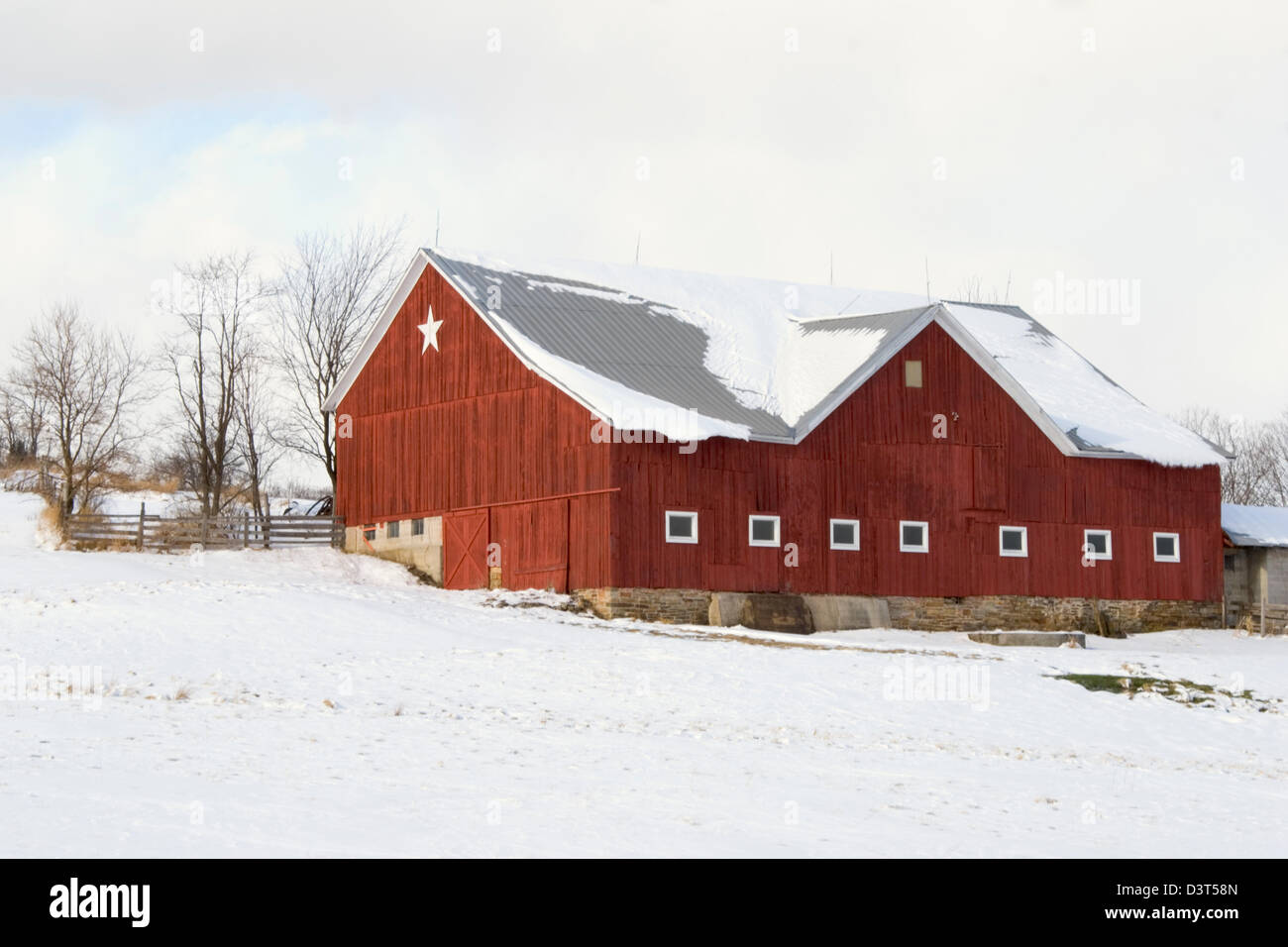 Red barn in winter snow with white star for decoration, a farm in Pennsylvania, PA, USA. Stock Photo