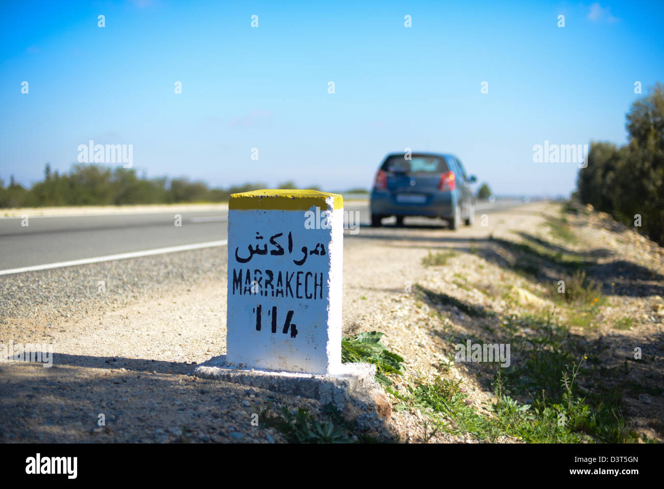 Milestone for Marrakech along the road from Essaouira Stock Photo