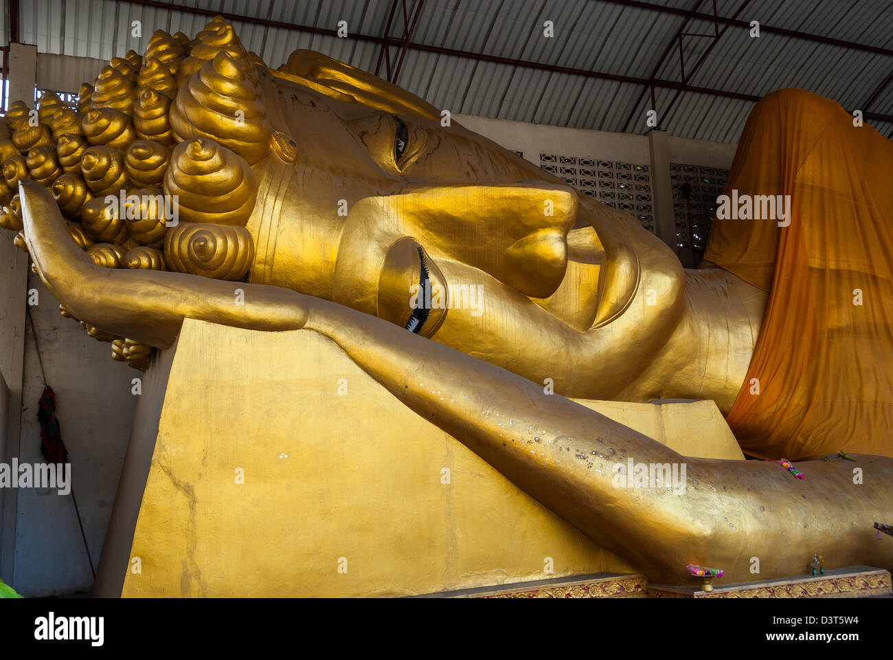 Big golden head of Reclining Buddha Image (Phra Norn) Stock Photo
