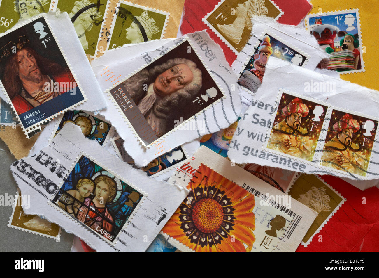 pile of used British postage stamps torn off envelopes and postcards