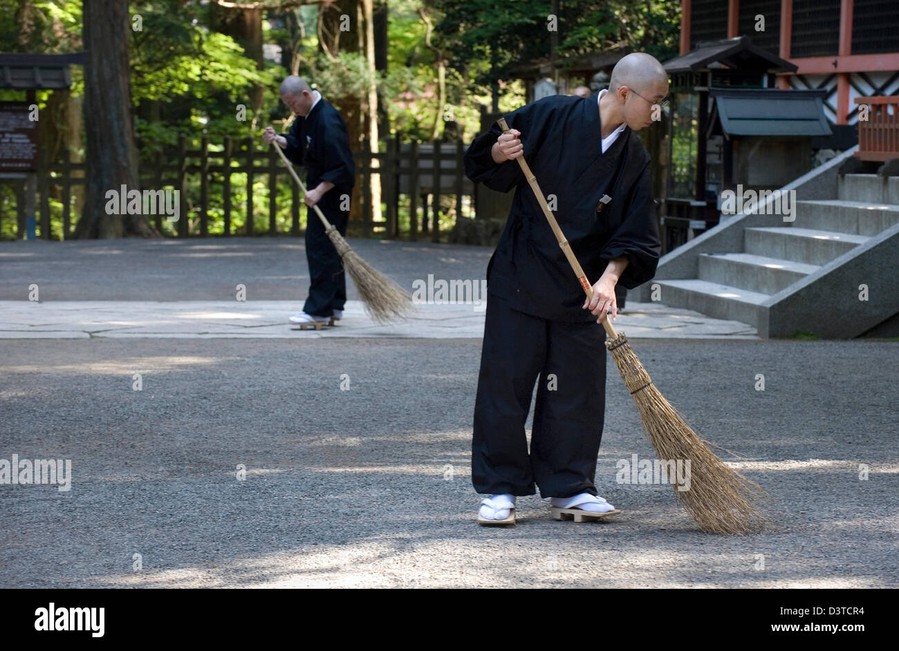 Buddhist monks on sweeping duty at Myo Jinja shrine in the Danjo Garan
