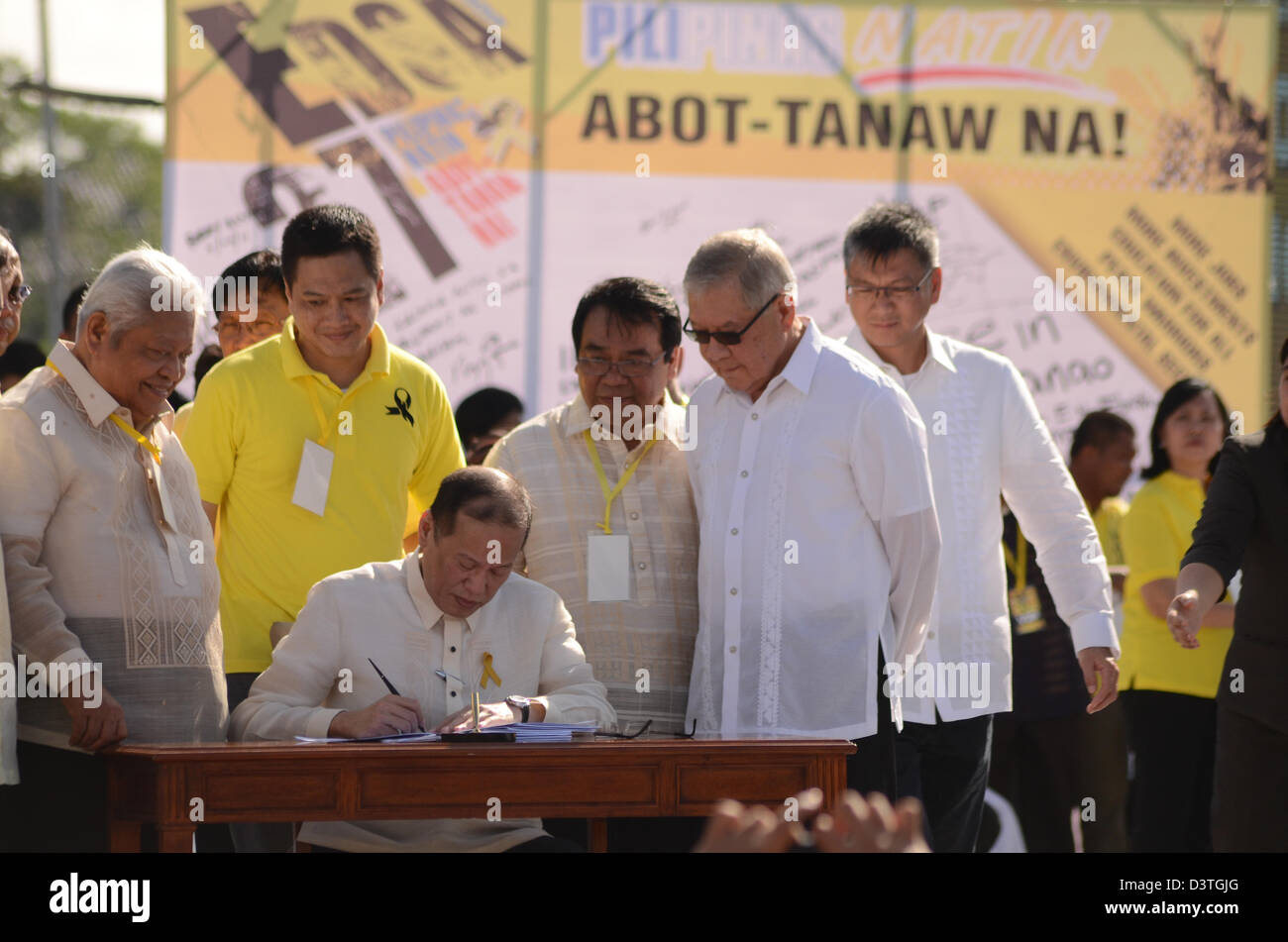 Quezon City, Manila, Philippines. 25th February 2013.  President Benigno Aquino III (sitting) signs into law the Human Rights Victims Reparation and Recognition Act of 2013, which grants reparation for human rights violations during the Martial Law rule of former president Ferdinand Marcos, during the commemoration of the 27th People Power Revolution on Monday, February 25. (Photo by Mark Demayo/Alamy Live News) Stock Photo