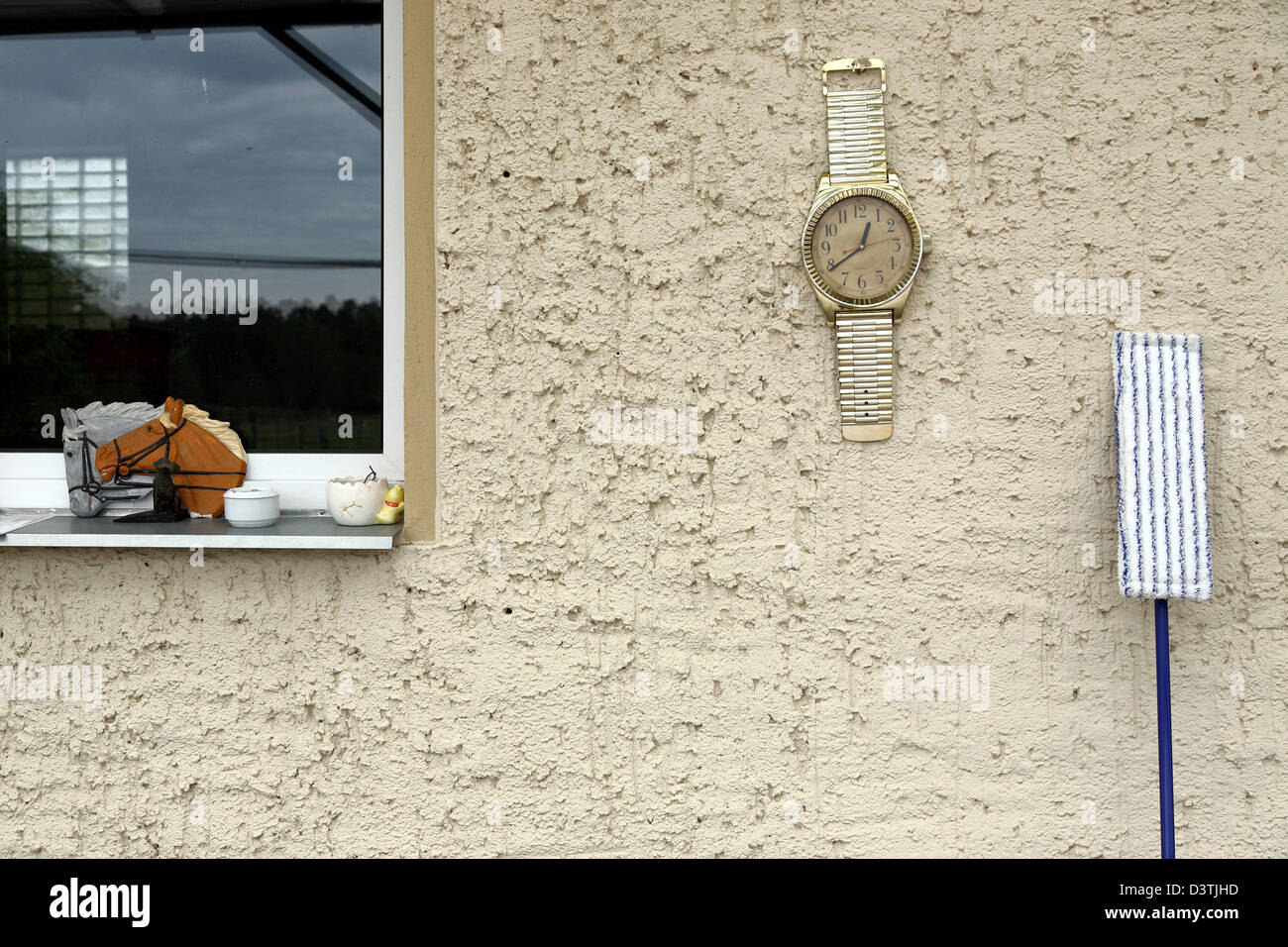 Birkholz, Germany, over a large wristwatch and mop on a house wall Stock Photo