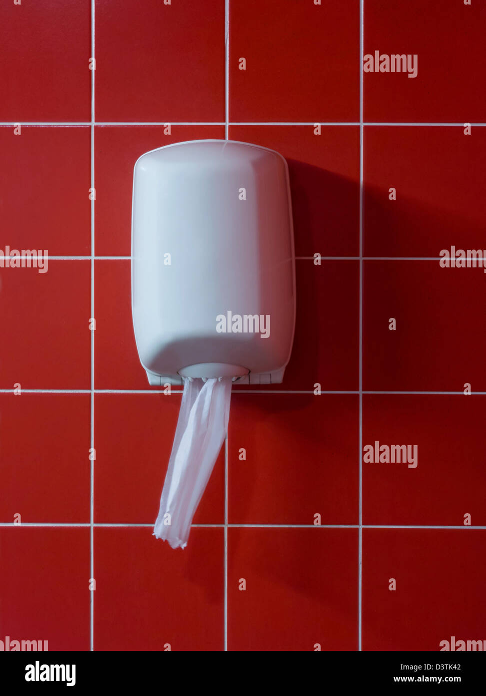 Toilet paper dispenser hanging on wall of restroom or bathroom Stock