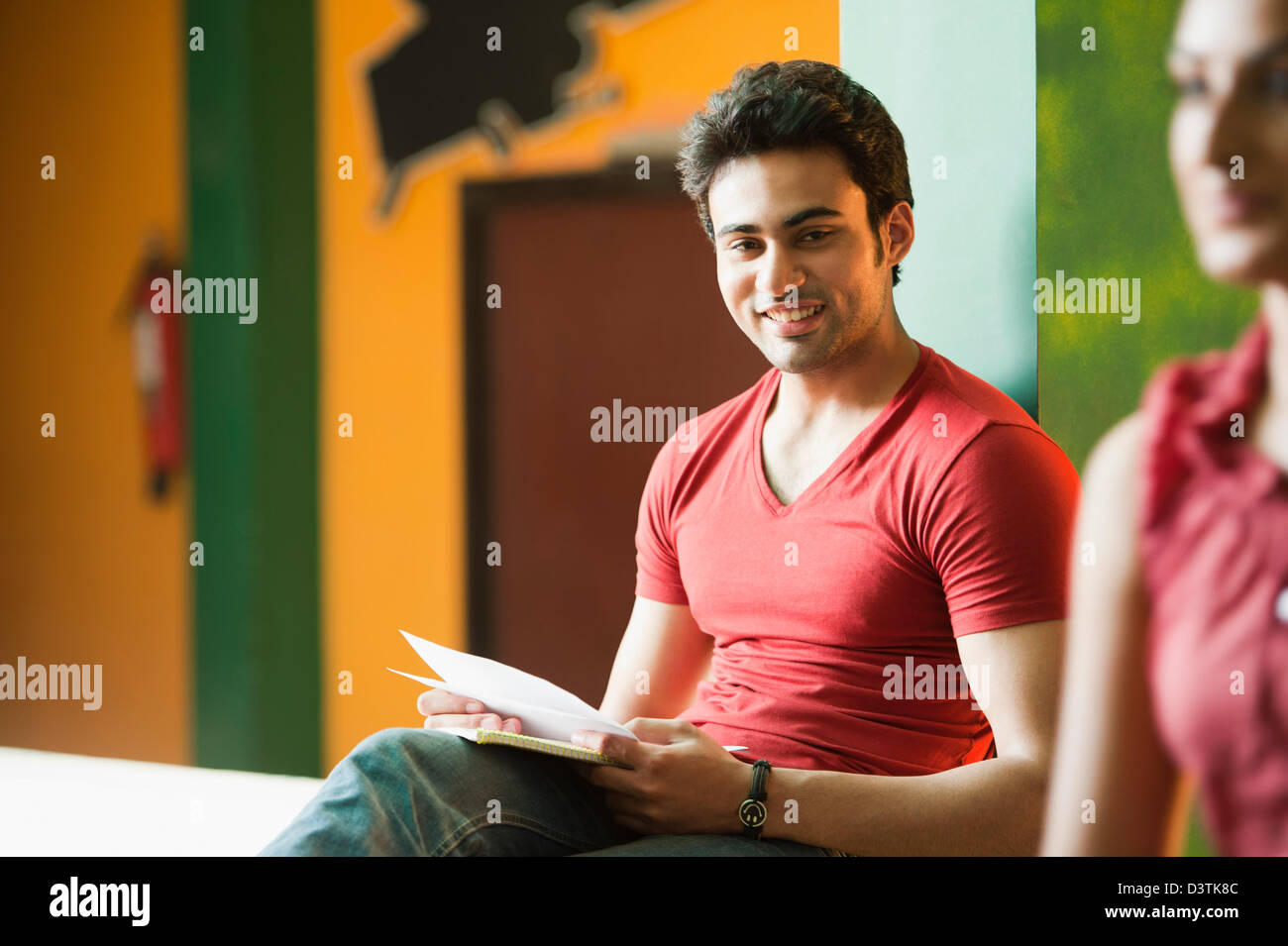 University student sitting with books and smiling Stock Photo - Alamy