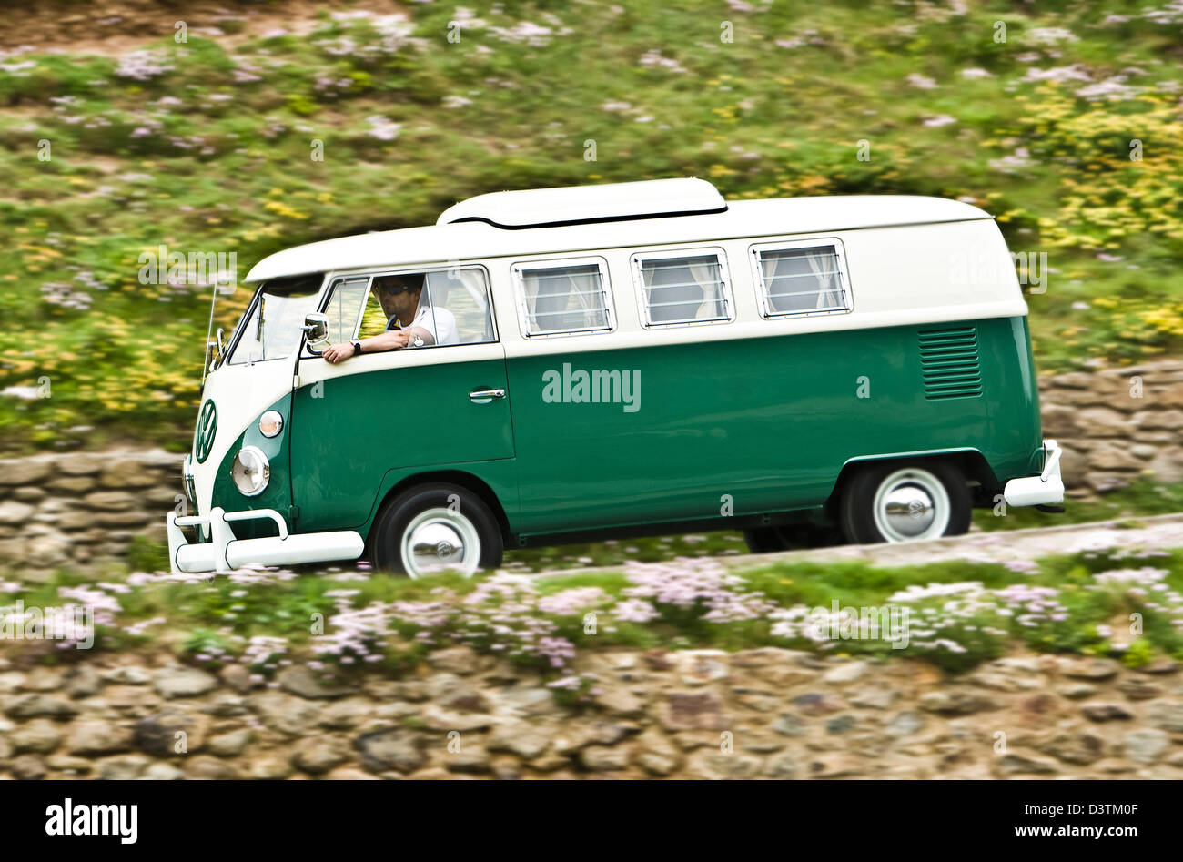 Green VW campervan on coastal road, St Agnes, Cornwall, UK Stock Photo