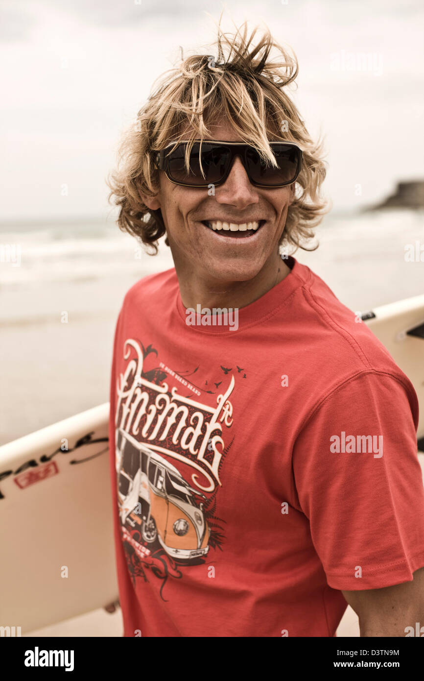Surfer stands laughing with board, surf fashion, St Agnes, Cornwall, UK  Stock Photo - Alamy