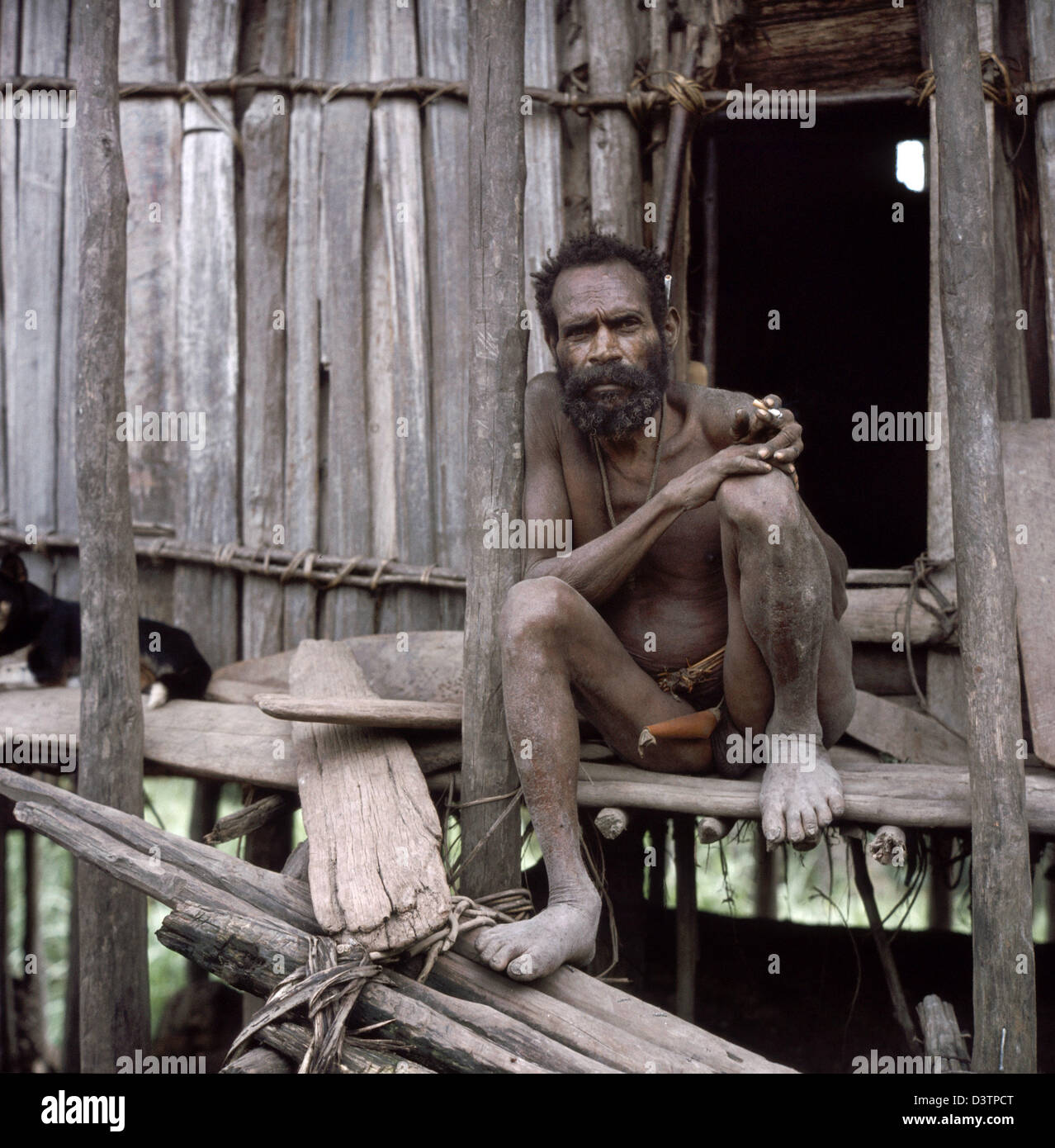The undated pictures shows a Papua man wearing only a penis tube sitting in  front of his hut while smoking a cigarette in Papua New Guinea. The  population of Papua New Guinea