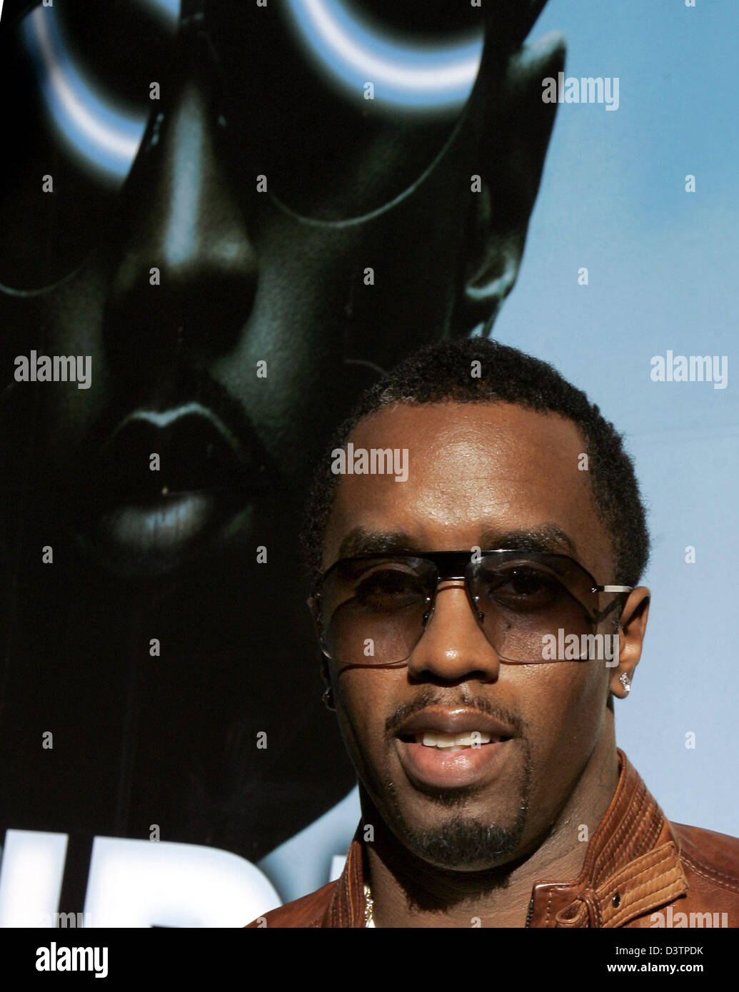 Musician P.Diddy poses in front of a giant poster advertising his