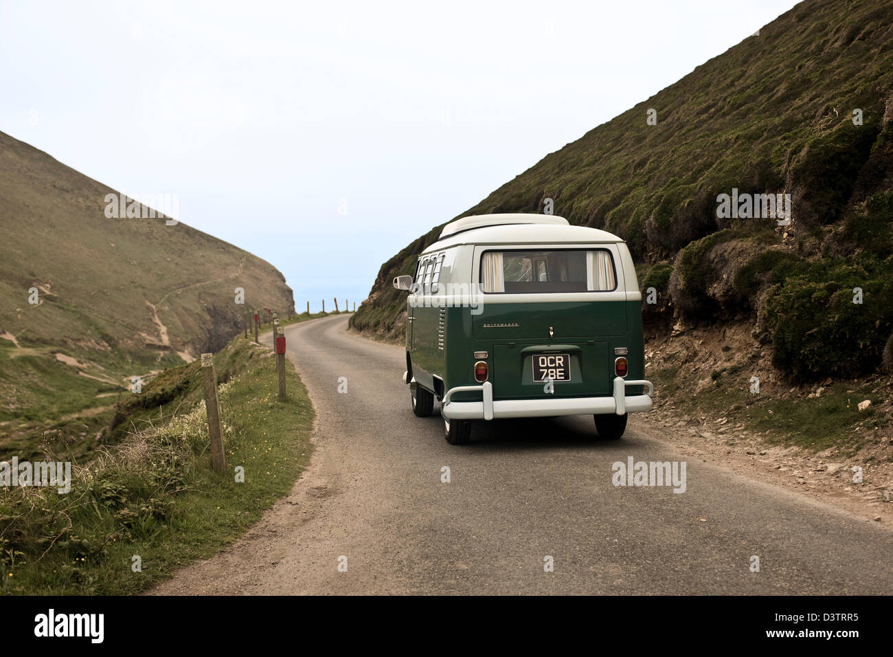 VW campervan on coastal road, St Agnes, Cornwall, UK Stock Photo