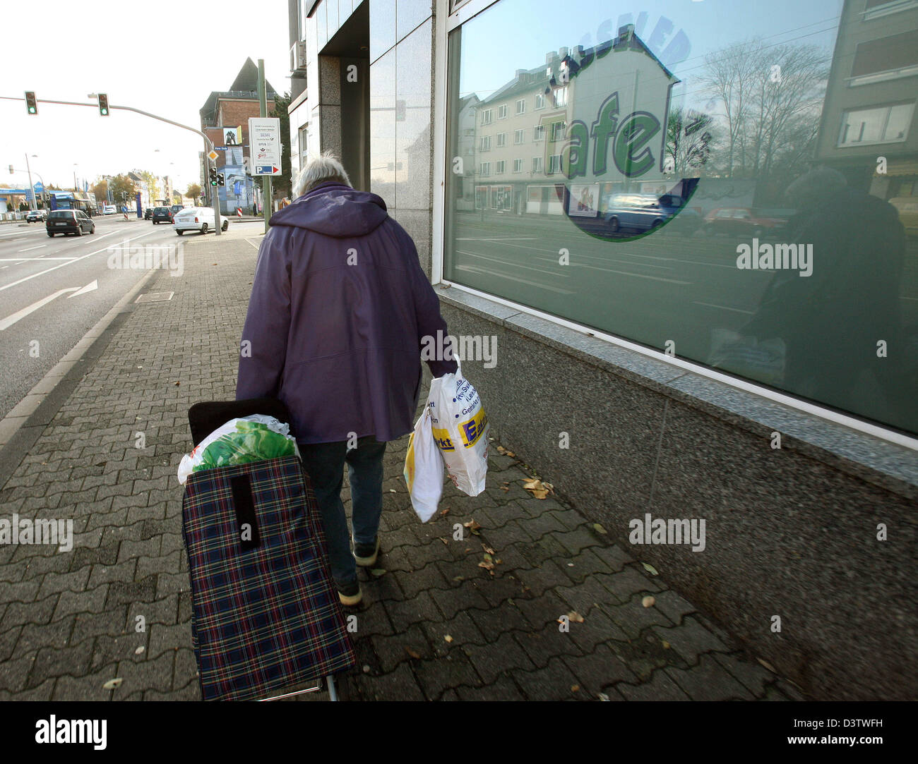 A Female Person Pulling A Trolley And Carrying Plastic Bags Leaves