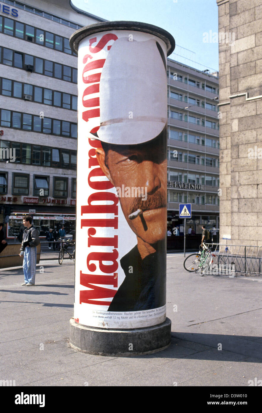 (dpa files) - The so called 'Marlboro Man' glances from an advertising column in Frankfurt Main, Germany, 1980s. Photo: Friederike von Stackelberg Stock Photo