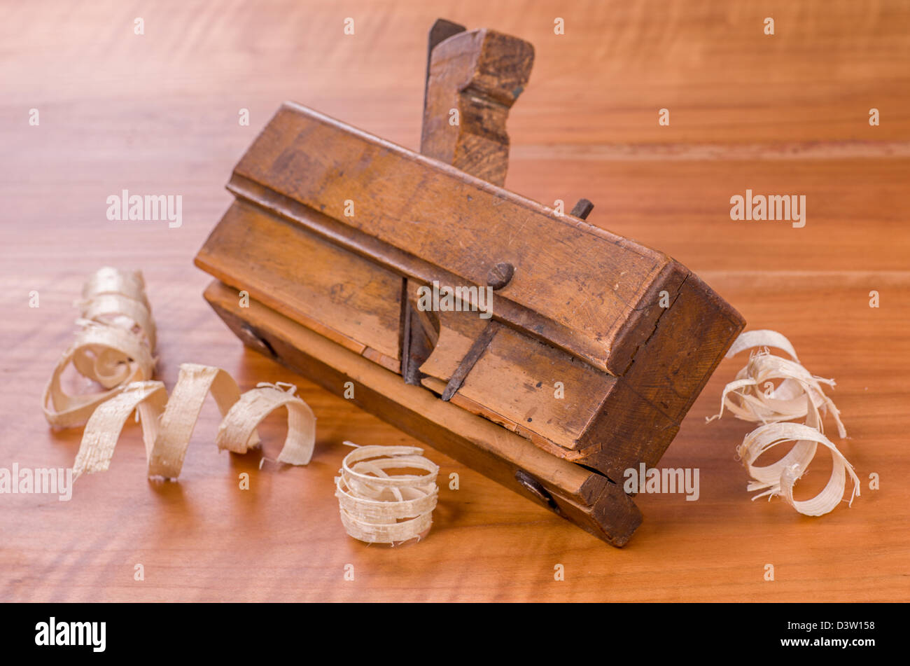 old molding plane with shavings on a cherry wood board Stock Photo