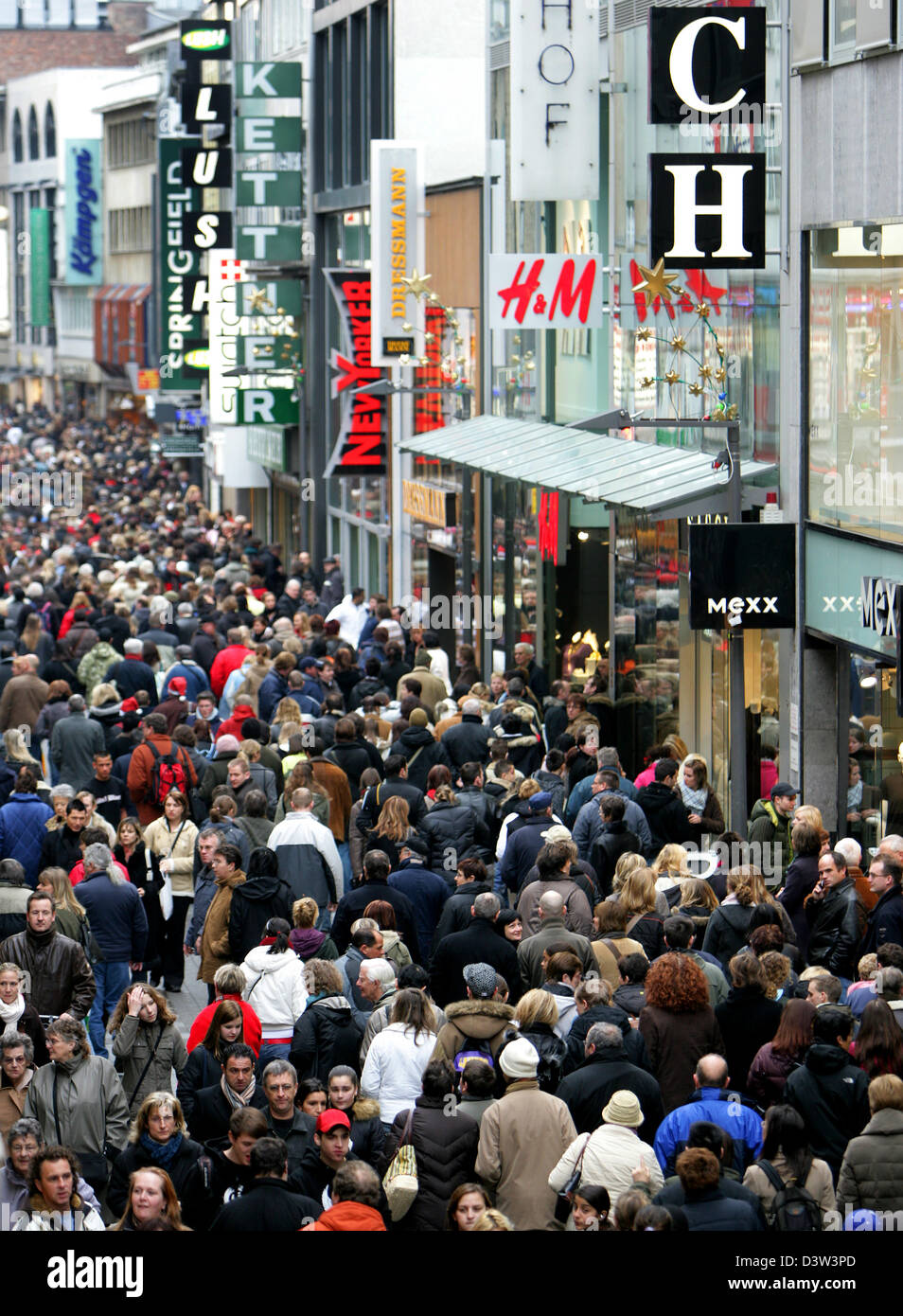 The masses move through a shopping street of Cologne, Germany, Saturday, 16 December 2006. The Central Association of German Retail Trade (HDE) expects a run on the shops for this Saturday. Expectations were high. It would be likely to be the top day in this year's Christmas business. So states head of HDE Hubertus Pellengahr to the dpa. The 3rd Sunday in Advent would be mainly use Stock Photo