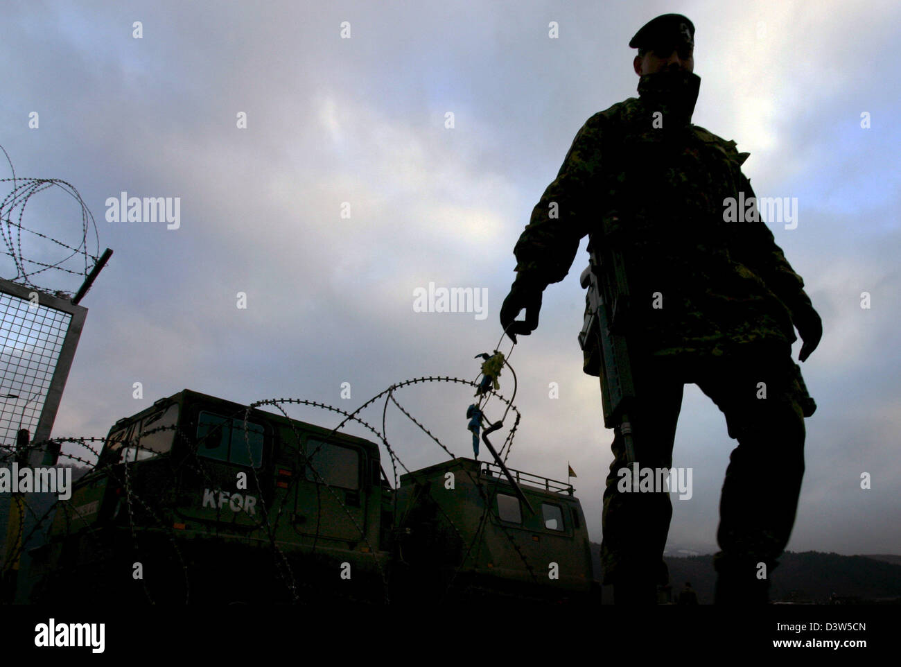 A soldiers uncoils a roll of barbed wire at the Bundeswehr camp 'Nothing Hill' north of Mitrovica, Serbia, 11 December 2006. Administrated by the UN the Kosovo forms part of Serbia under international law. The camp erected only in July 2006 is the northernmost post of the KFOR troops in the Kosovo. Photo: Matthias Schrader Stock Photo