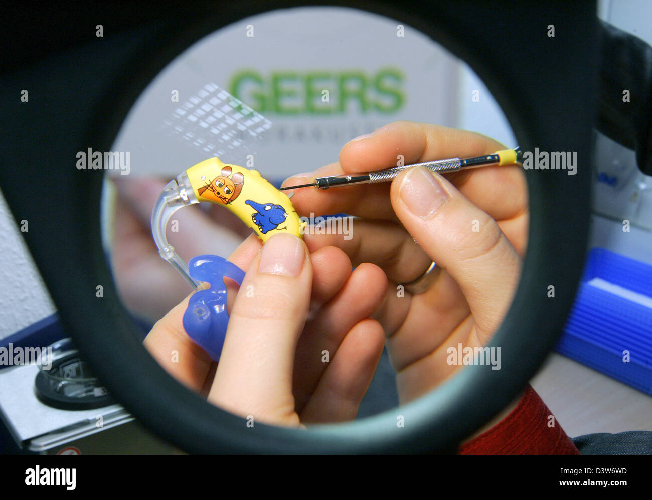 An acoustician checks a hearing aid for kids of German company Geers