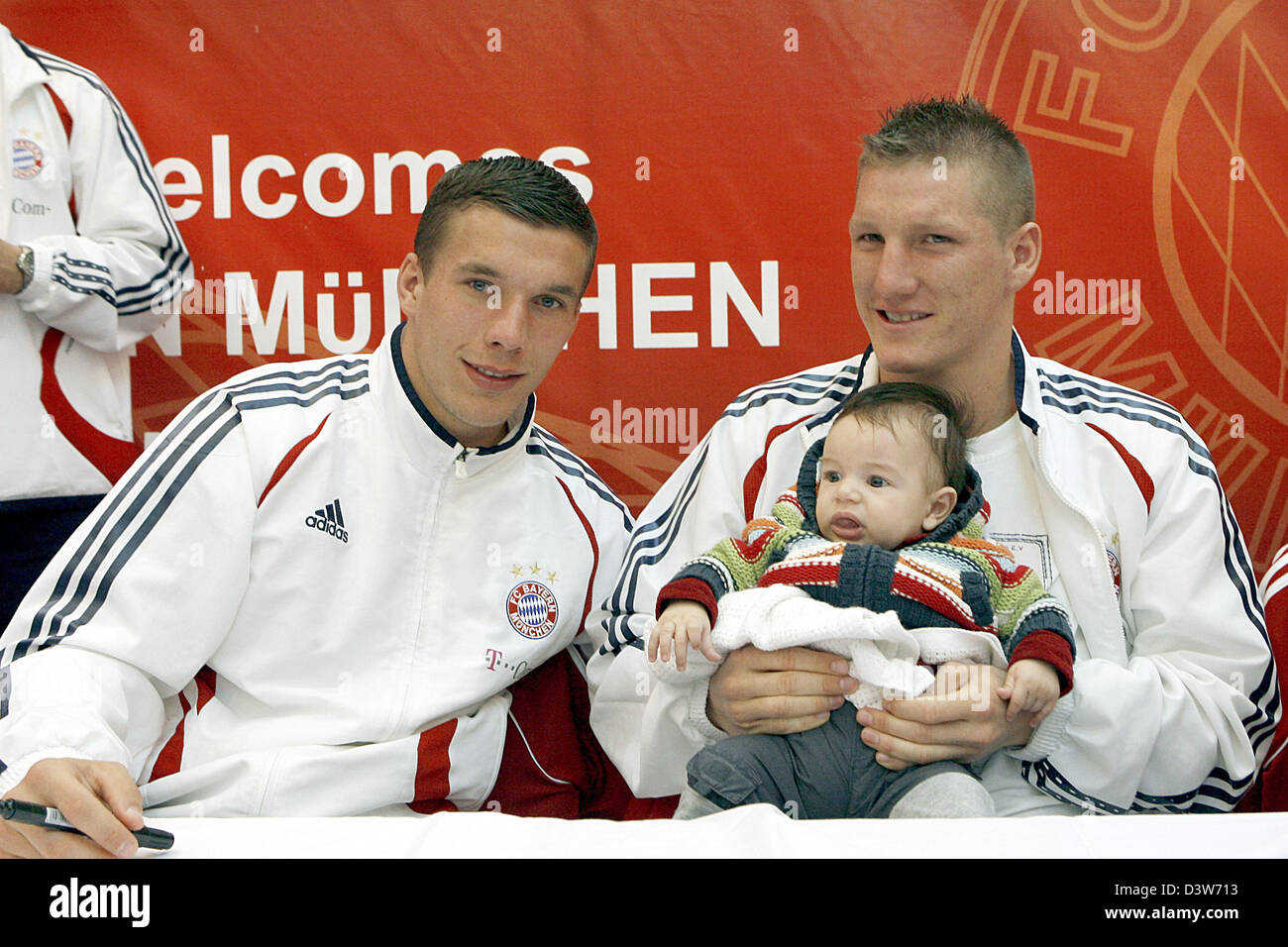 Lukas Podolski (L) and Bastian Schweinsteiger of FC Bayern Munich pose with a fan's child during an autograph session at an adidas store in Dubai, United Arab Emirates, Thursday 11 January 2207. Photo: Daniel Karmann Stock Photo