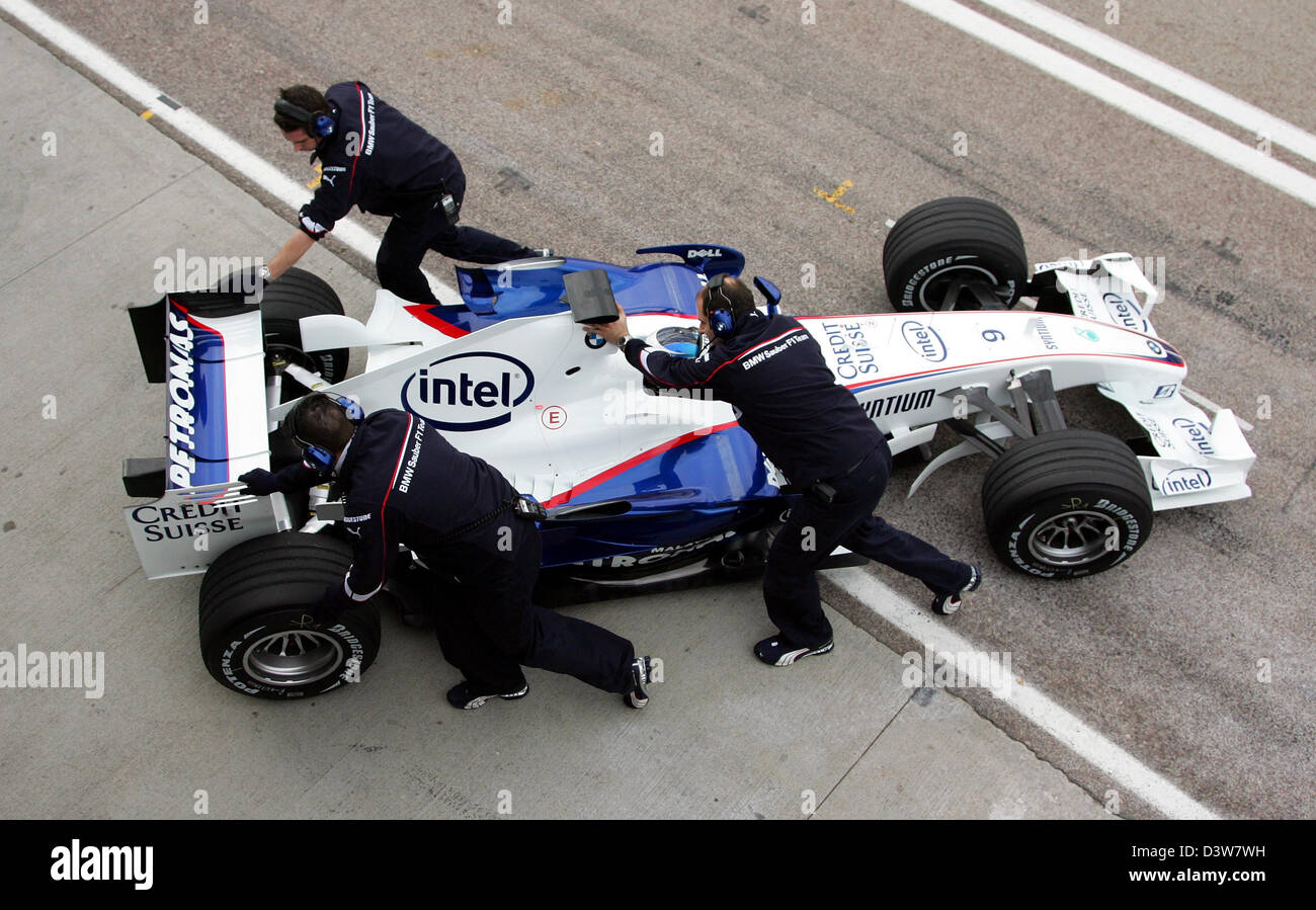 Mechanics push German Formula One pilot Nick Heidfeld of BMW Sauber in the team's new 'F1.07' back into the pit after it's virgin drive in Valencia, Spain, Tuesday, 16 January 2007. Photo: Gero Breloer Stock Photo