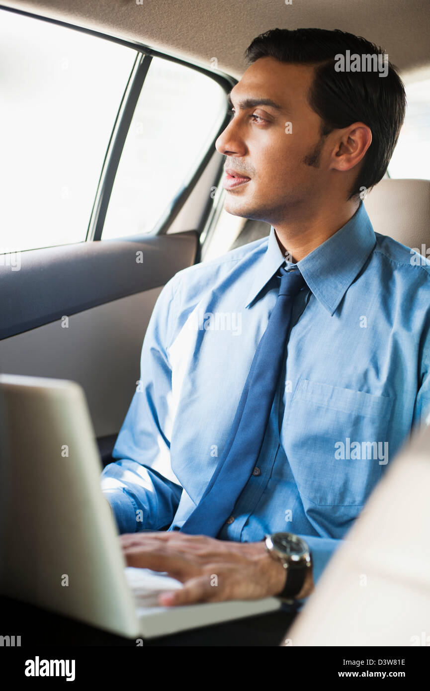 Bengali businessman using a laptop in a car Stock Photo