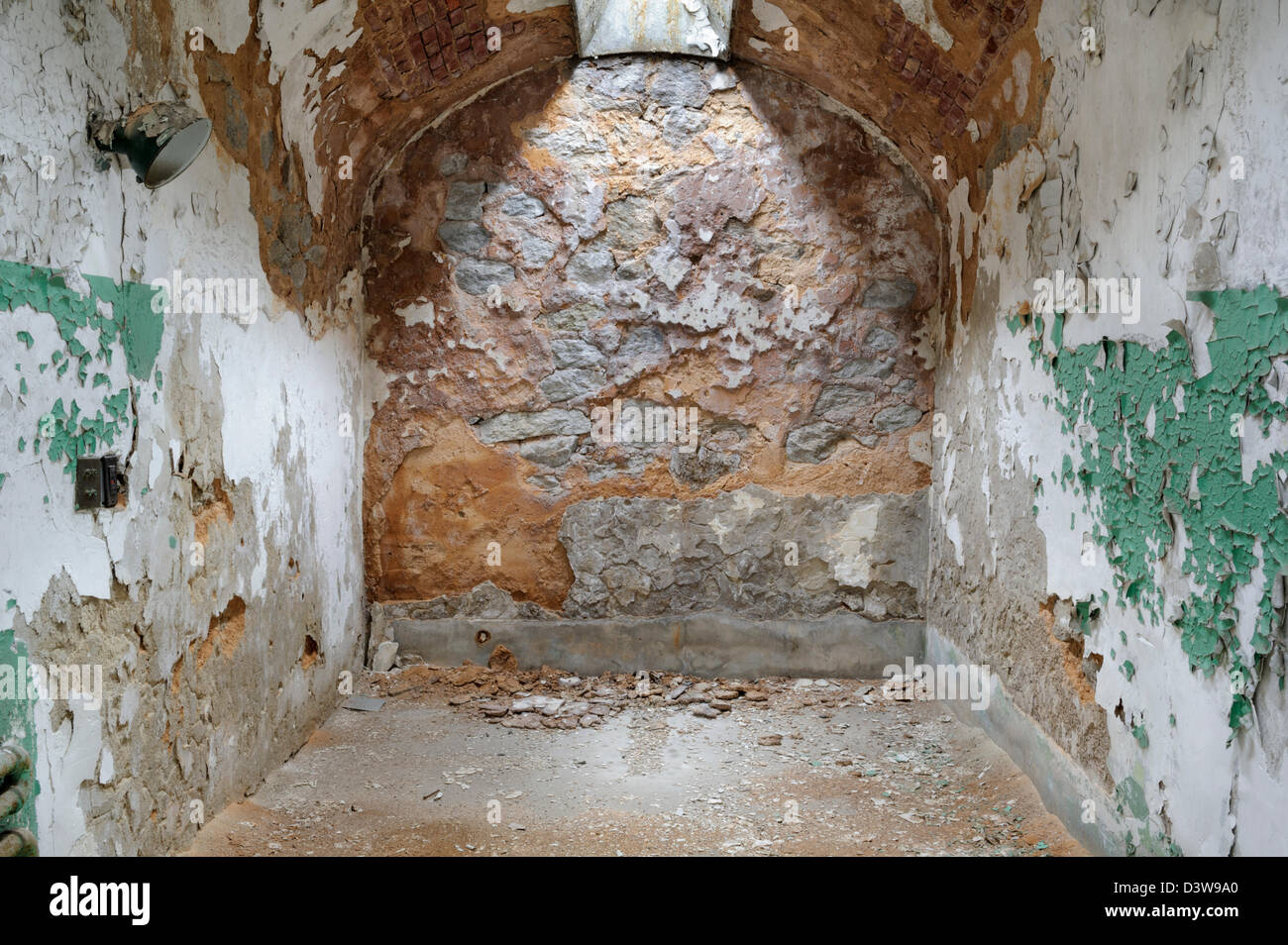 Abandoned prison cell rock wall background of natural stone with overhead skylight, Stock Photo