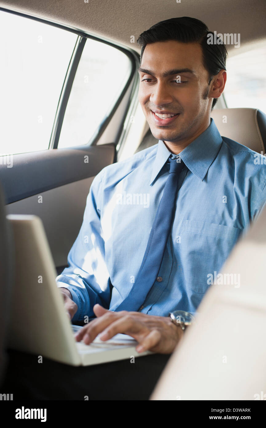 Bengali businessman using a laptop in a car Stock Photo Alamy